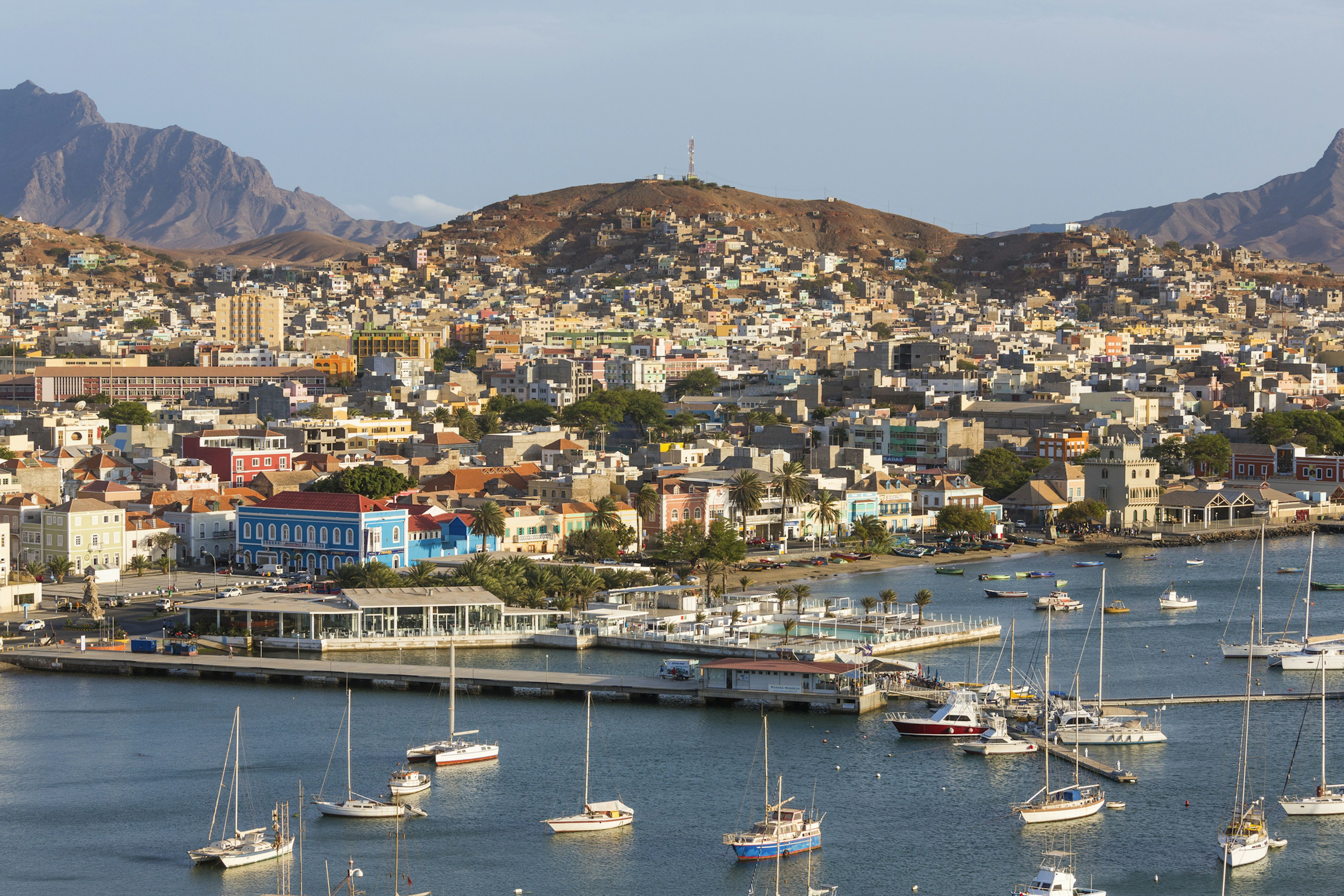 A port city, with some small boats docked offshore