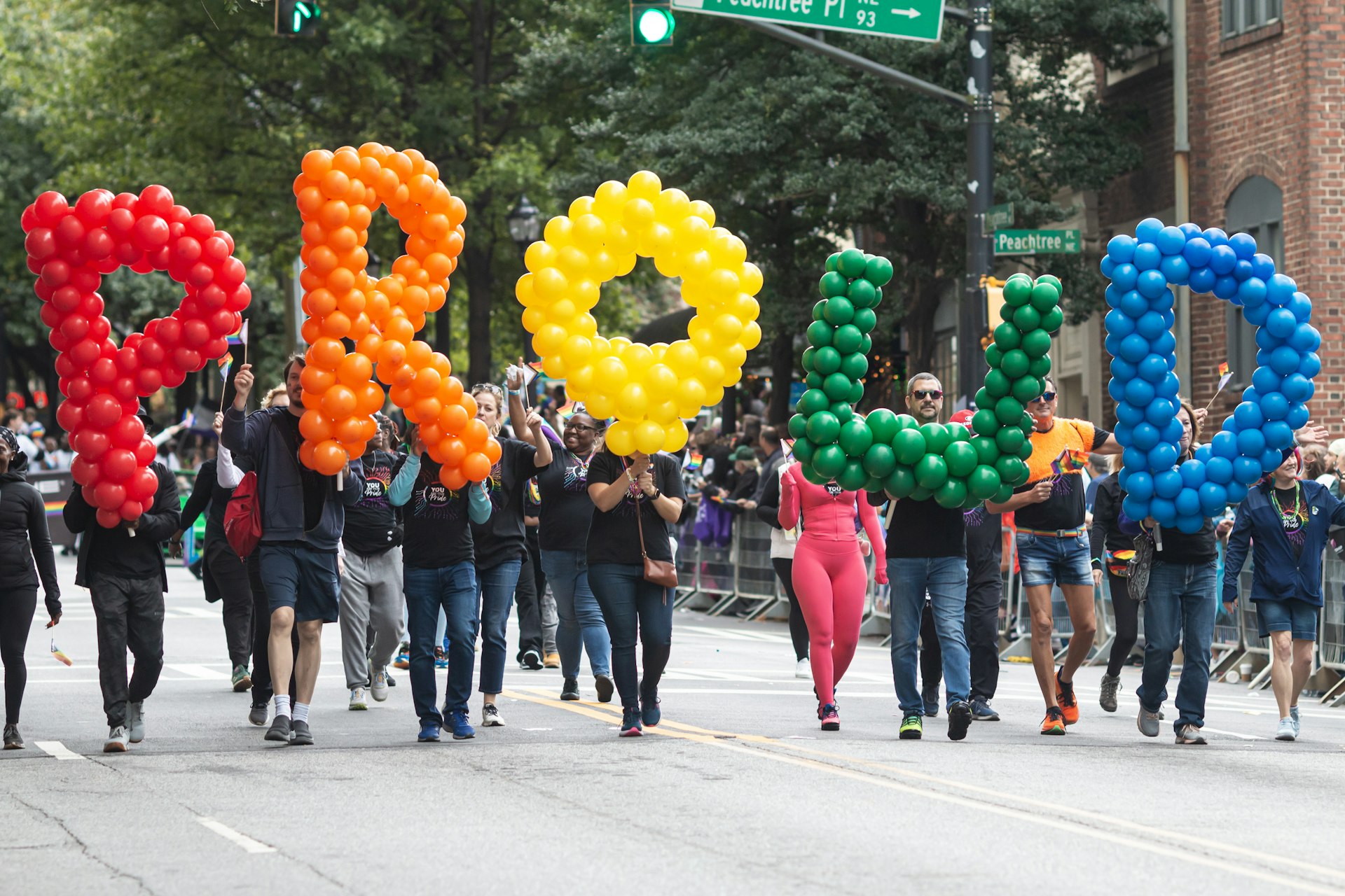 People carry large balloon letters that spell out "Proud" as they walk in the annual pride parade in Atlanta, Georgia (2023)