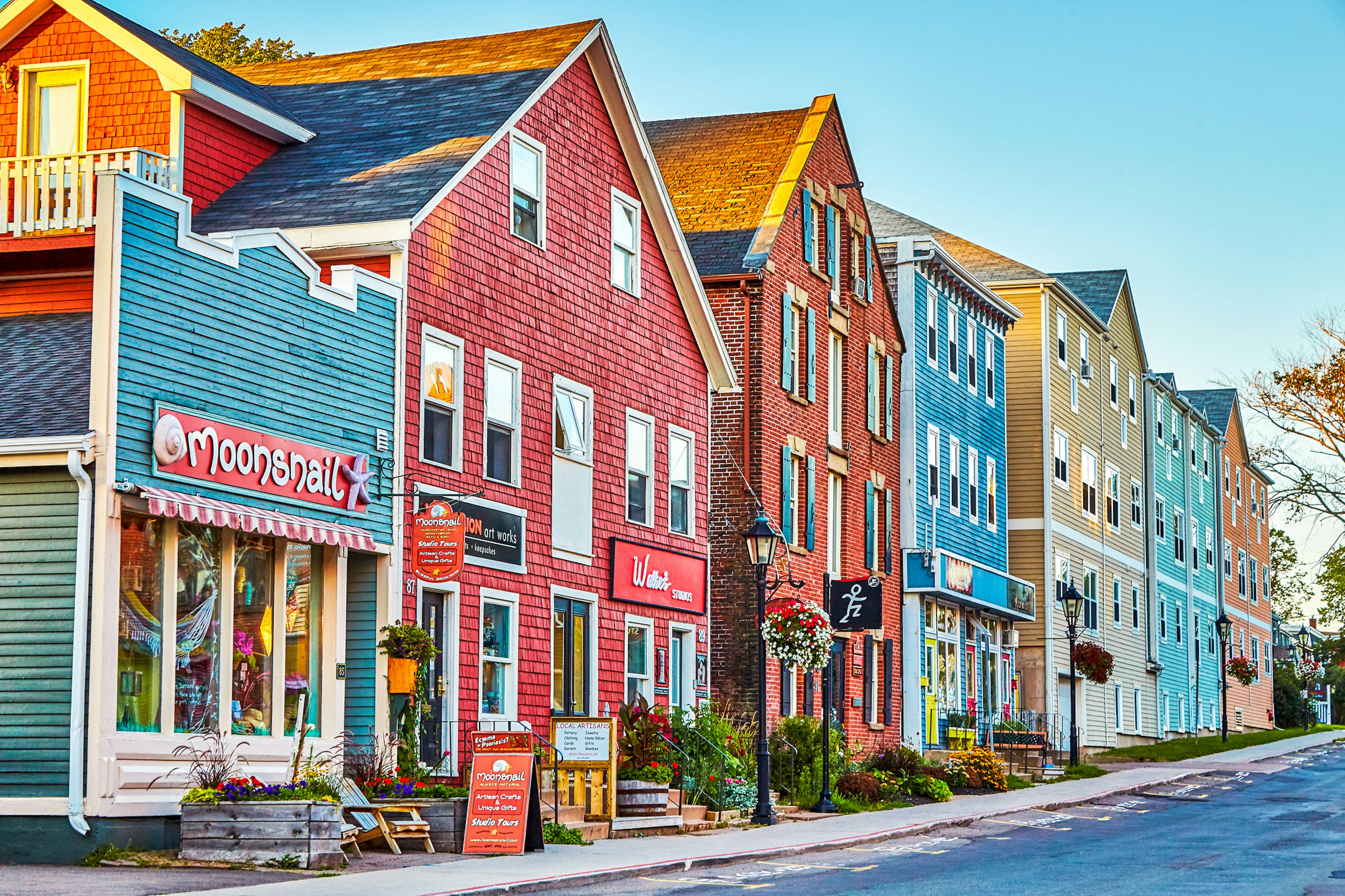 A row of shops with colorfully painted storefronts set on a slight incline