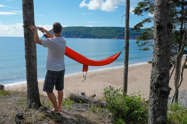 Man preparing hammock, Ingonish, Cape Breton, Nova Scotia, Canada