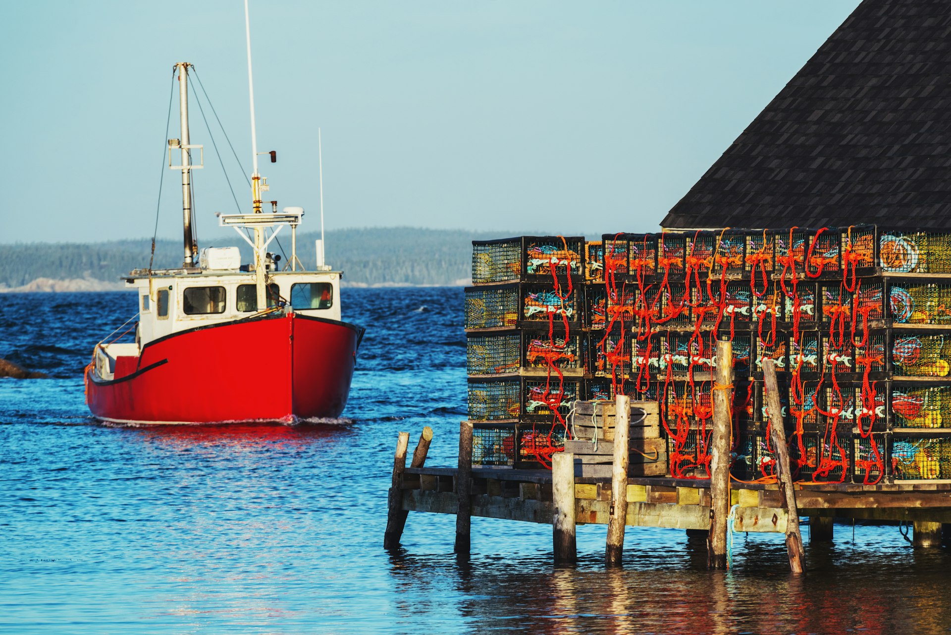 Um barco de lagosta se aproxima de um cais em Peggy's Cove, Nova Escócia, Canadá