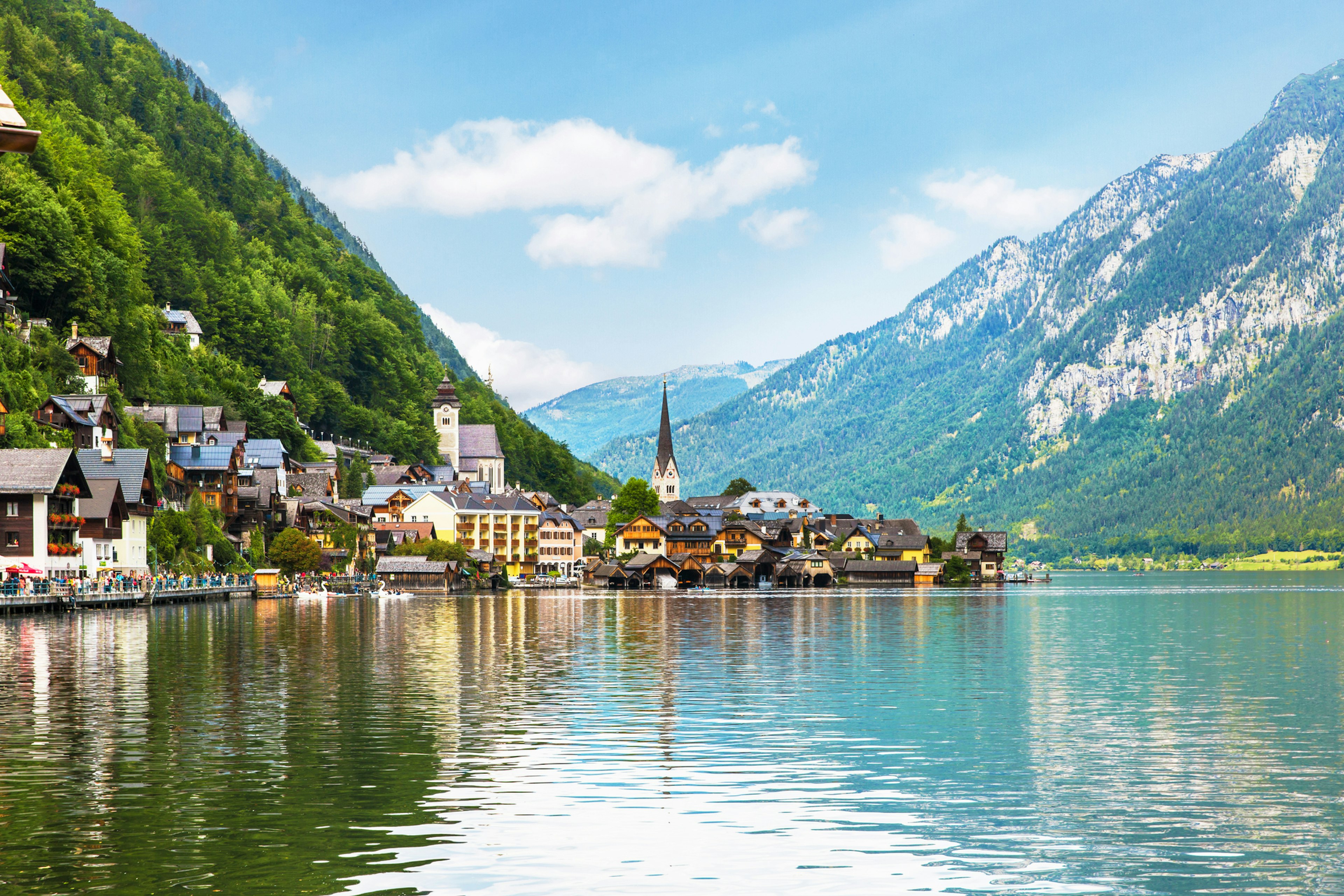 An alpine village with a church on the edge of a lake