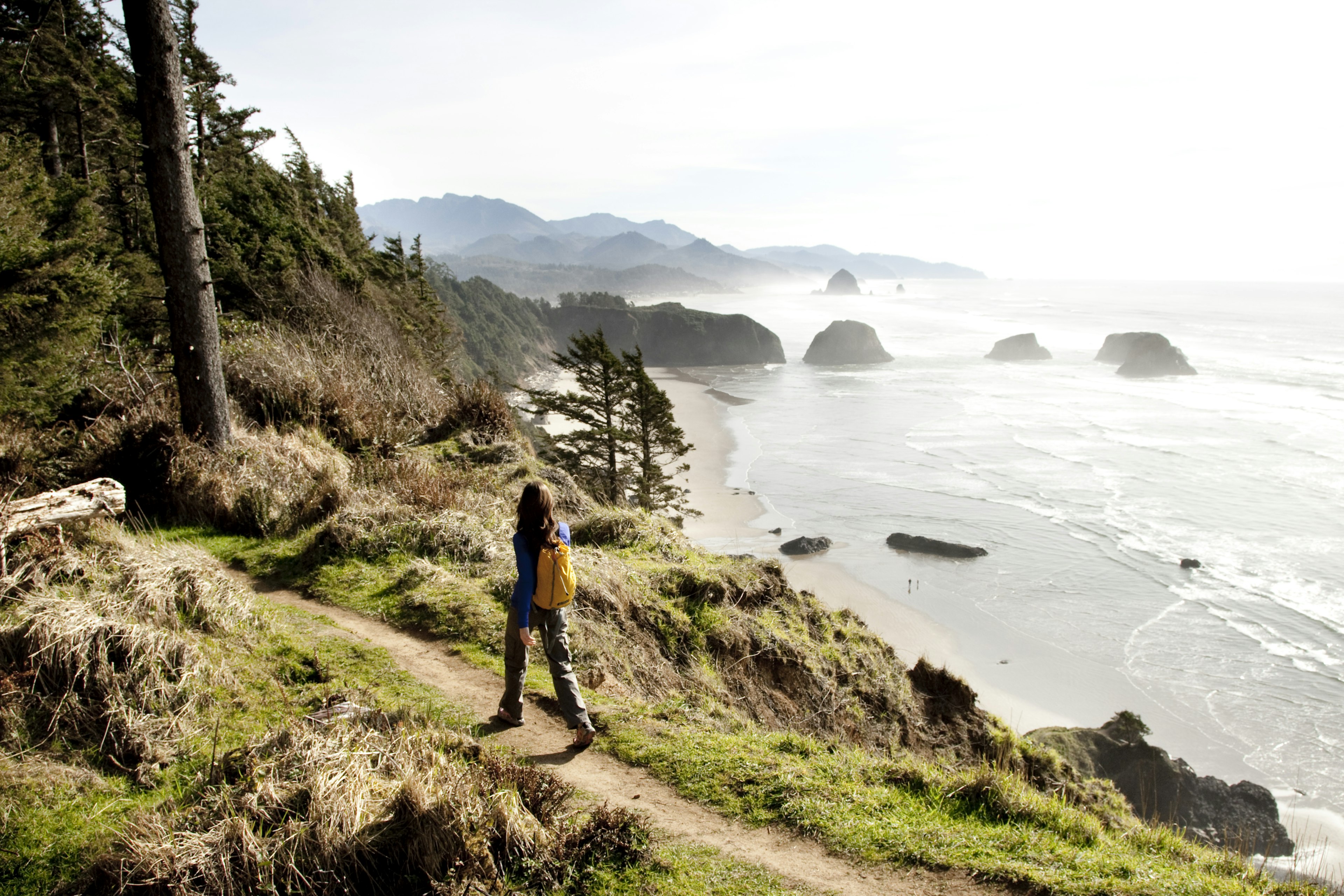 A woman hiking a secluded path along the coastline.