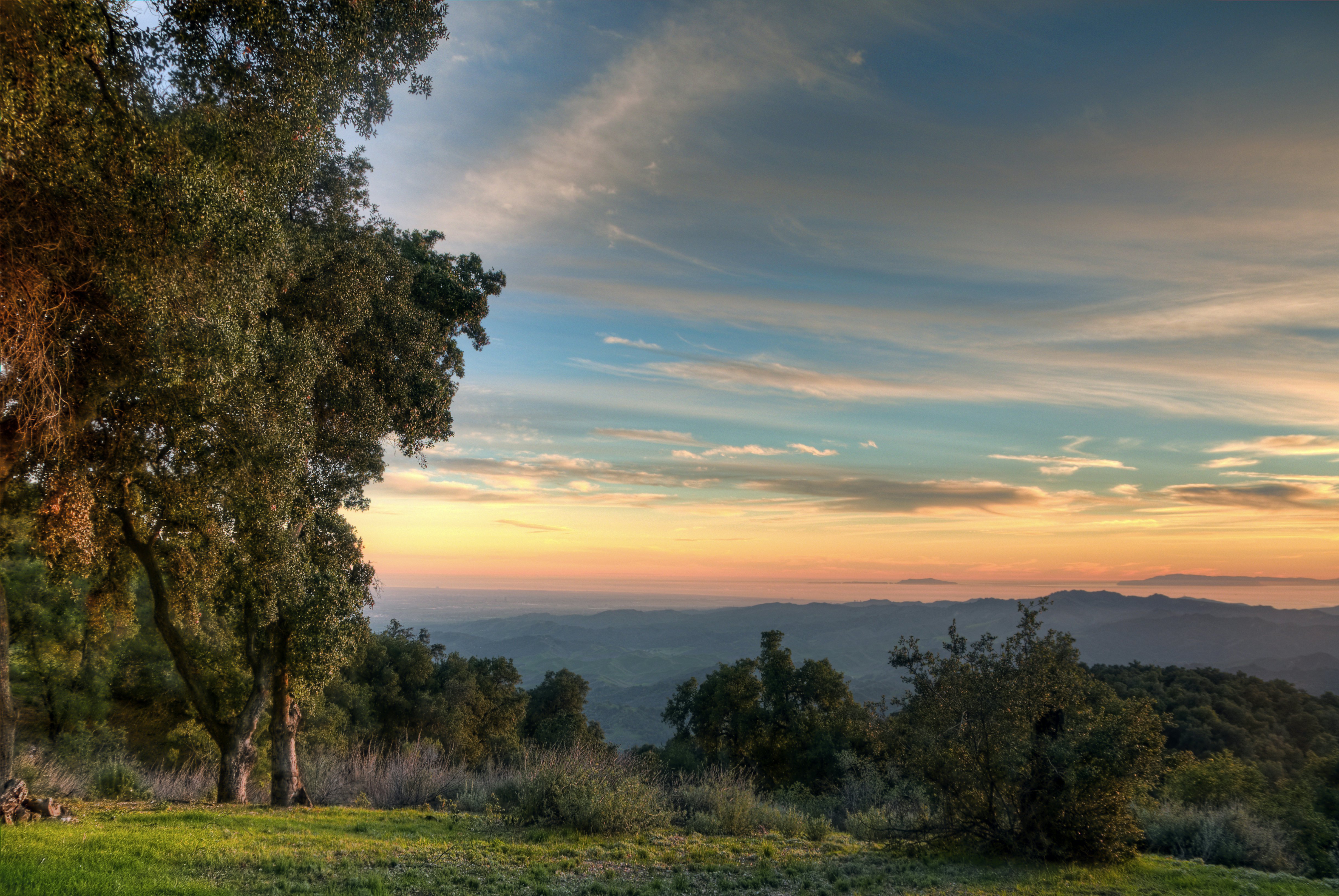 A beautiful sunset over hills that stretch into the misty distance as the light fades