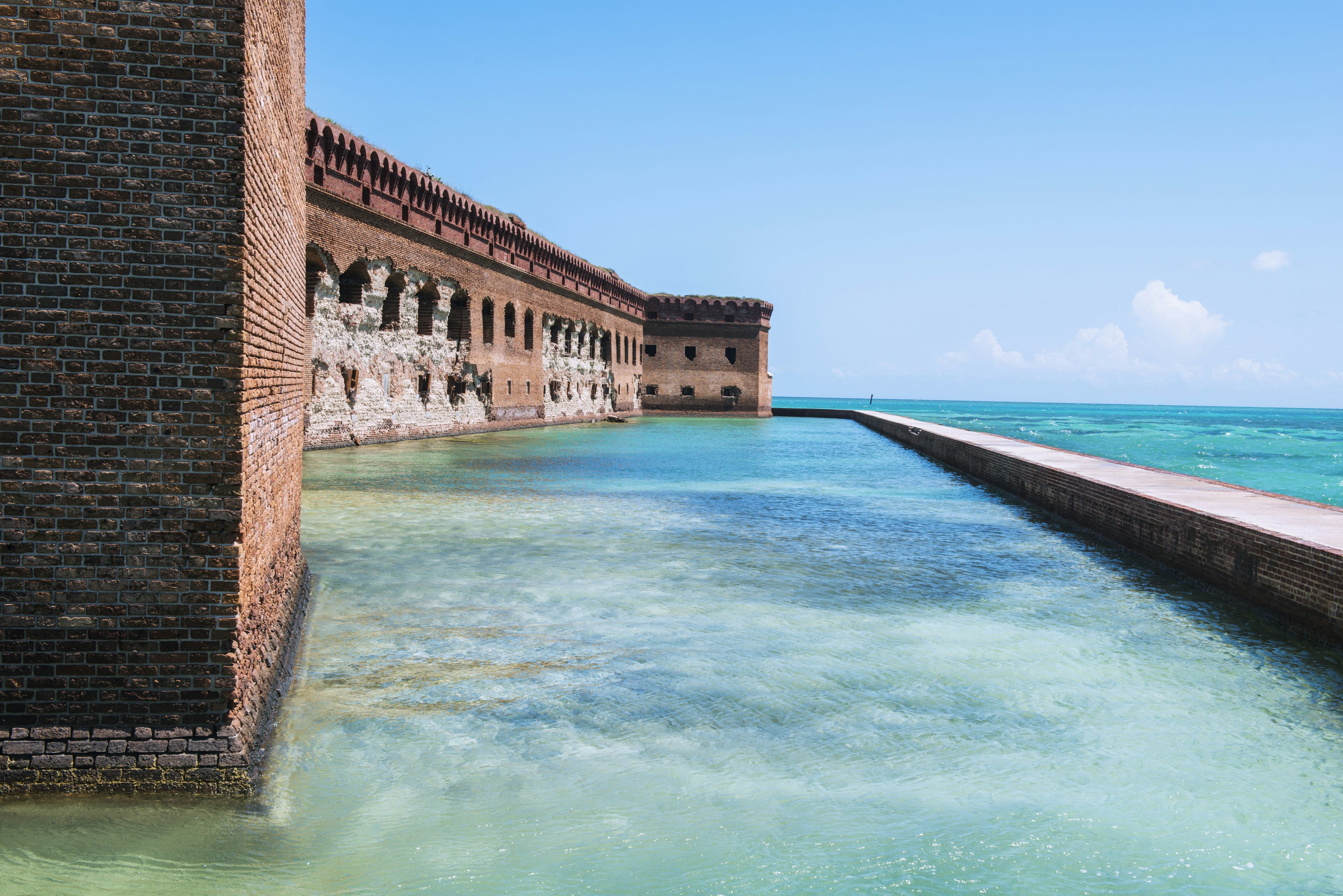 A brick fortress with a walkway at sea level