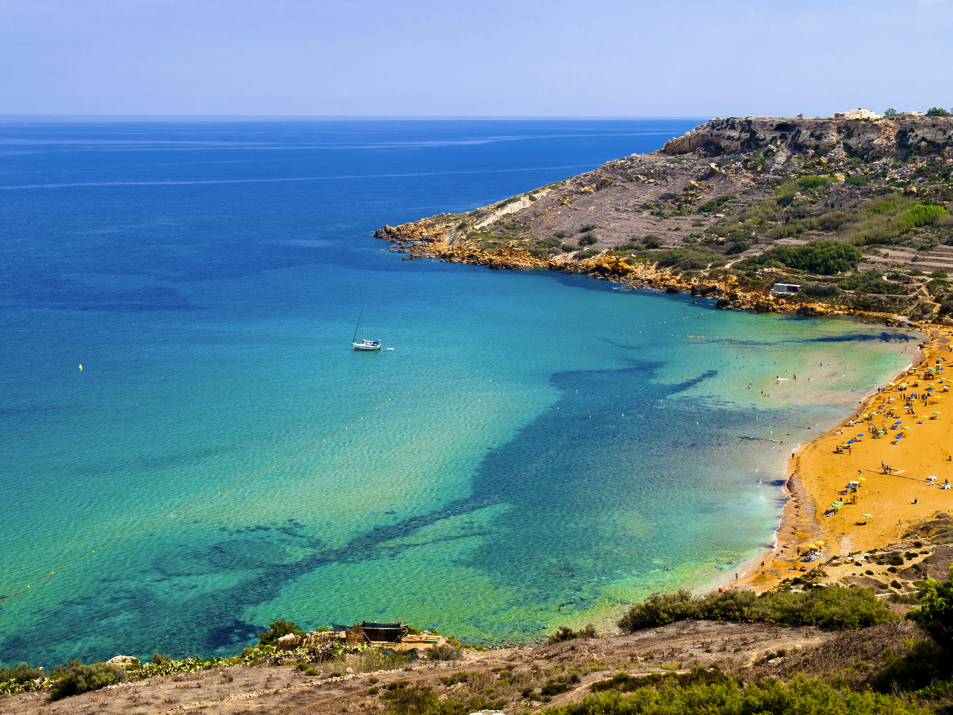 An orange-sand bay on the edge of turquoise ocean