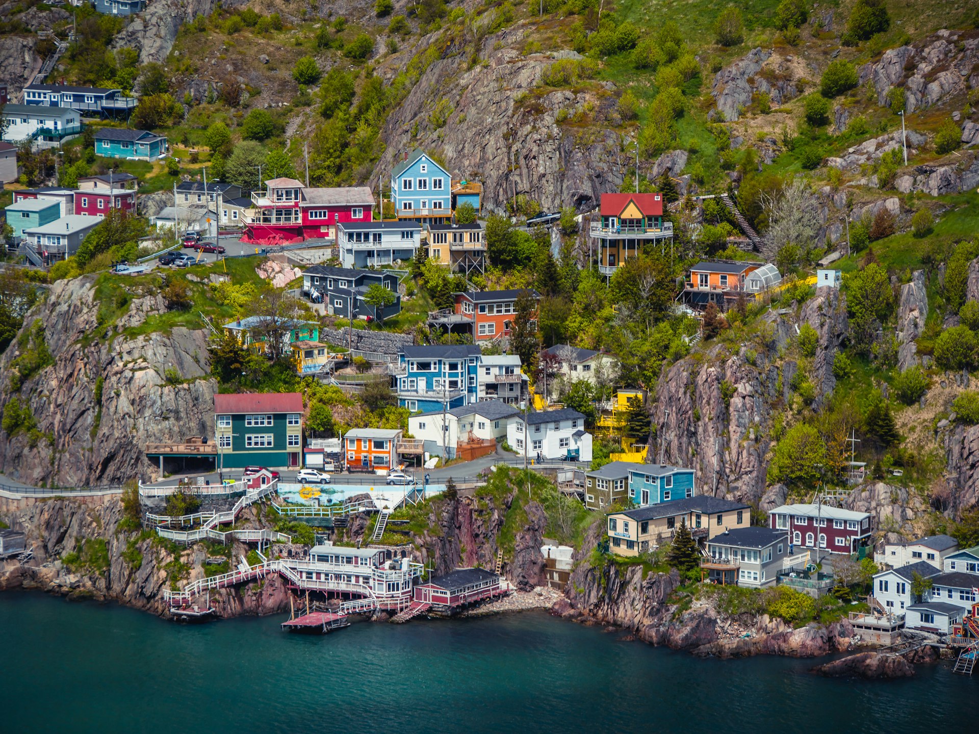 Buildings on the side of a rocky mountain by the sea at St. Johns, Newfoundland, Canada