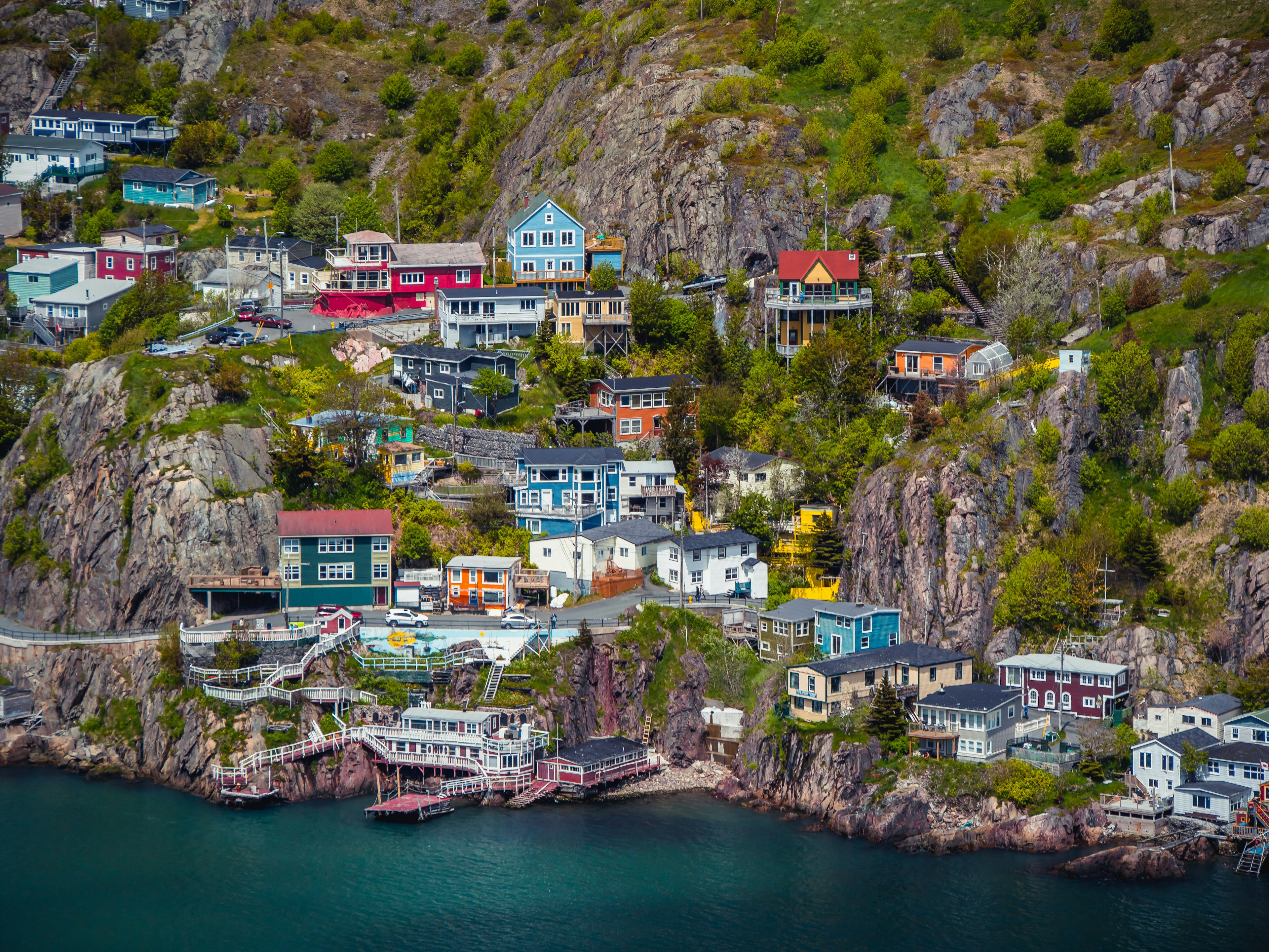 Buildings on the side of a rocky mountain by the sea at St. Johns, Newfoundland, Canada