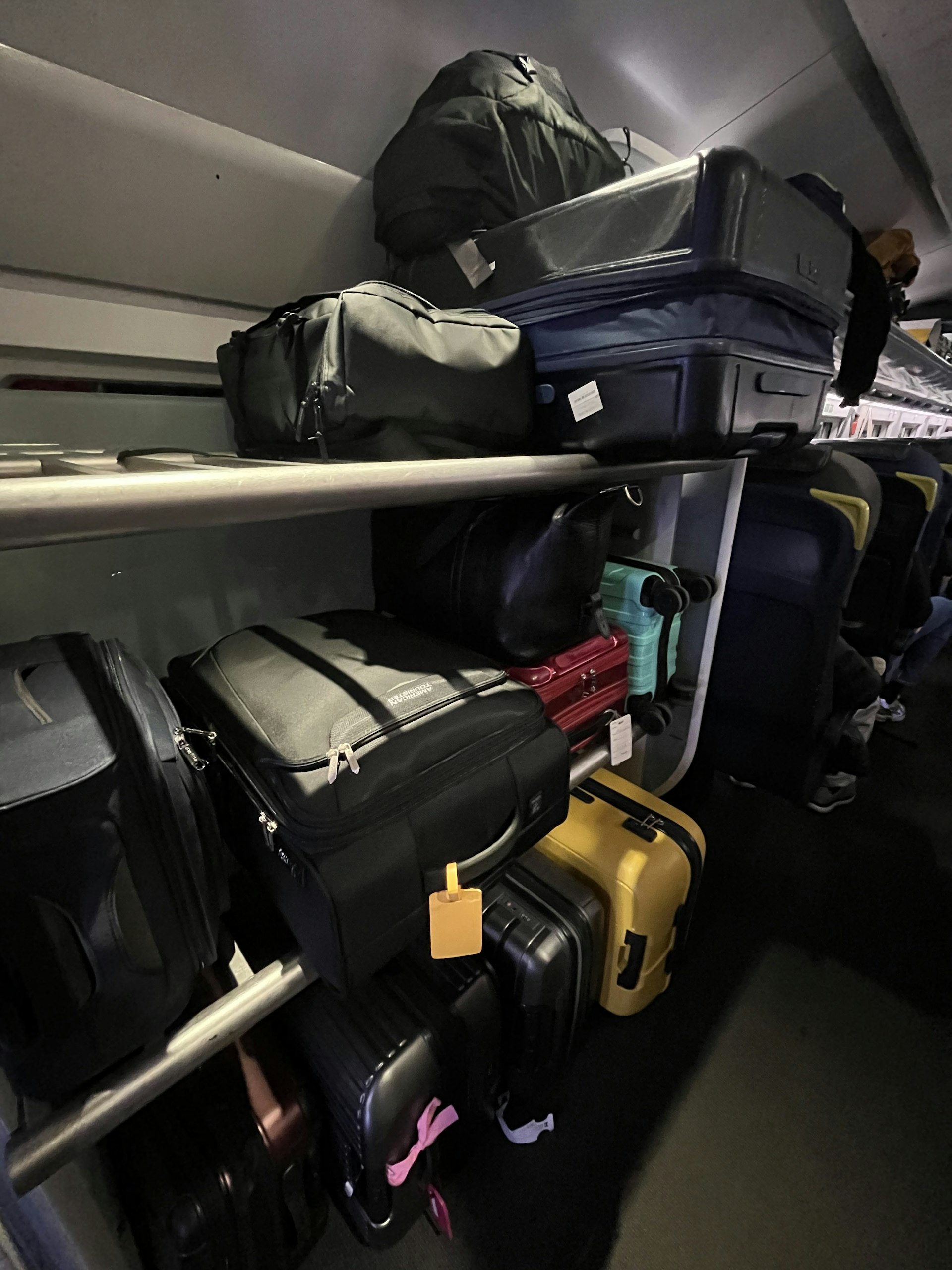 Suitcases and wheelie bags stacked on a luggage rack on board a train
