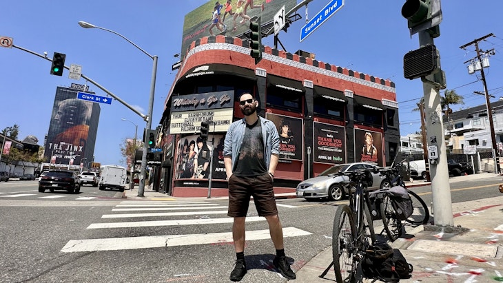 Writer James March stands in front of a bike during a sunny day in front of of Whiskey a Go Go on the Sunset Strip