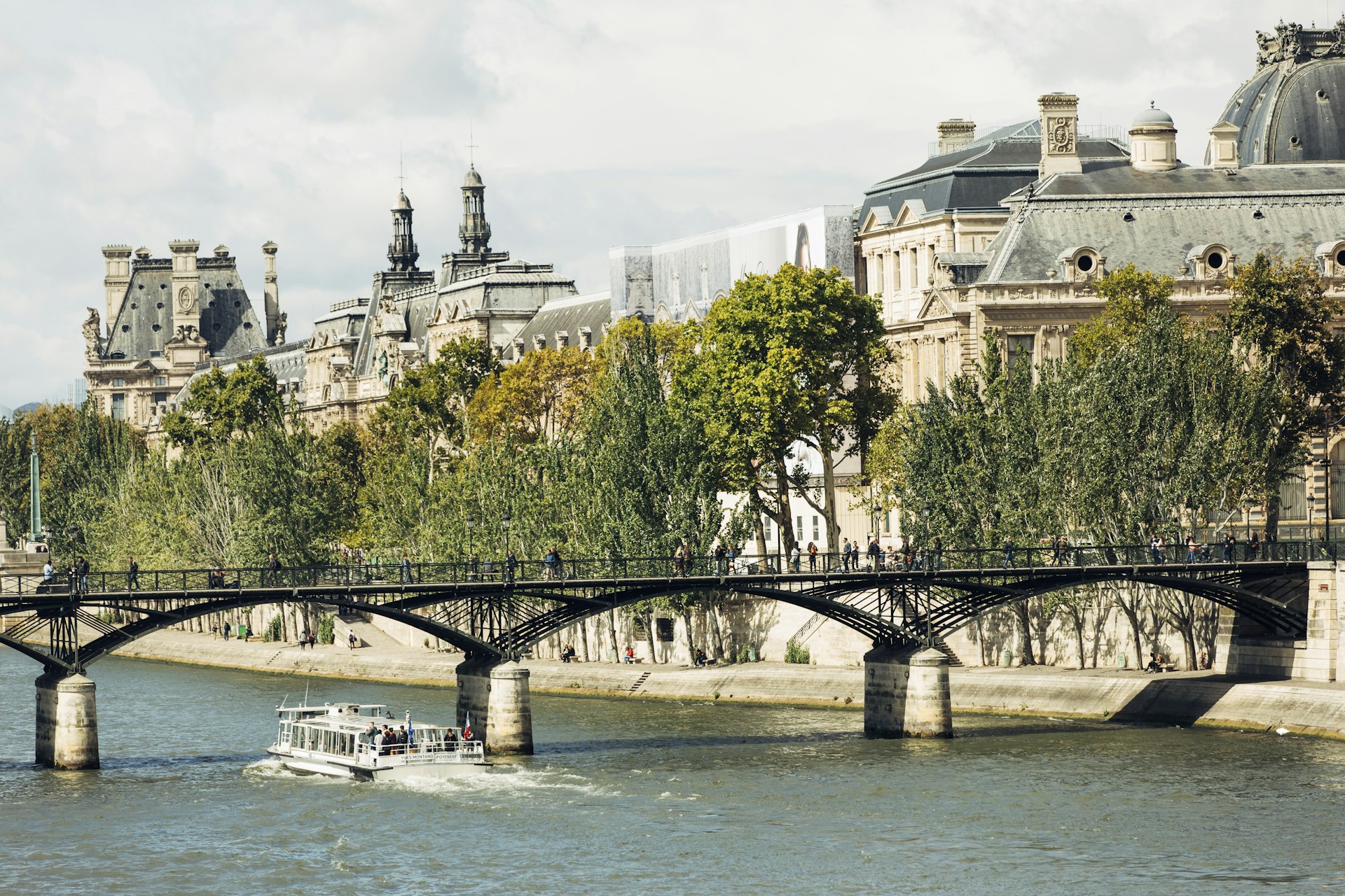 The pedestrian Pont des Arts crosses the River Seine, linking the Palais du Louvre (shown) and the Institut de France