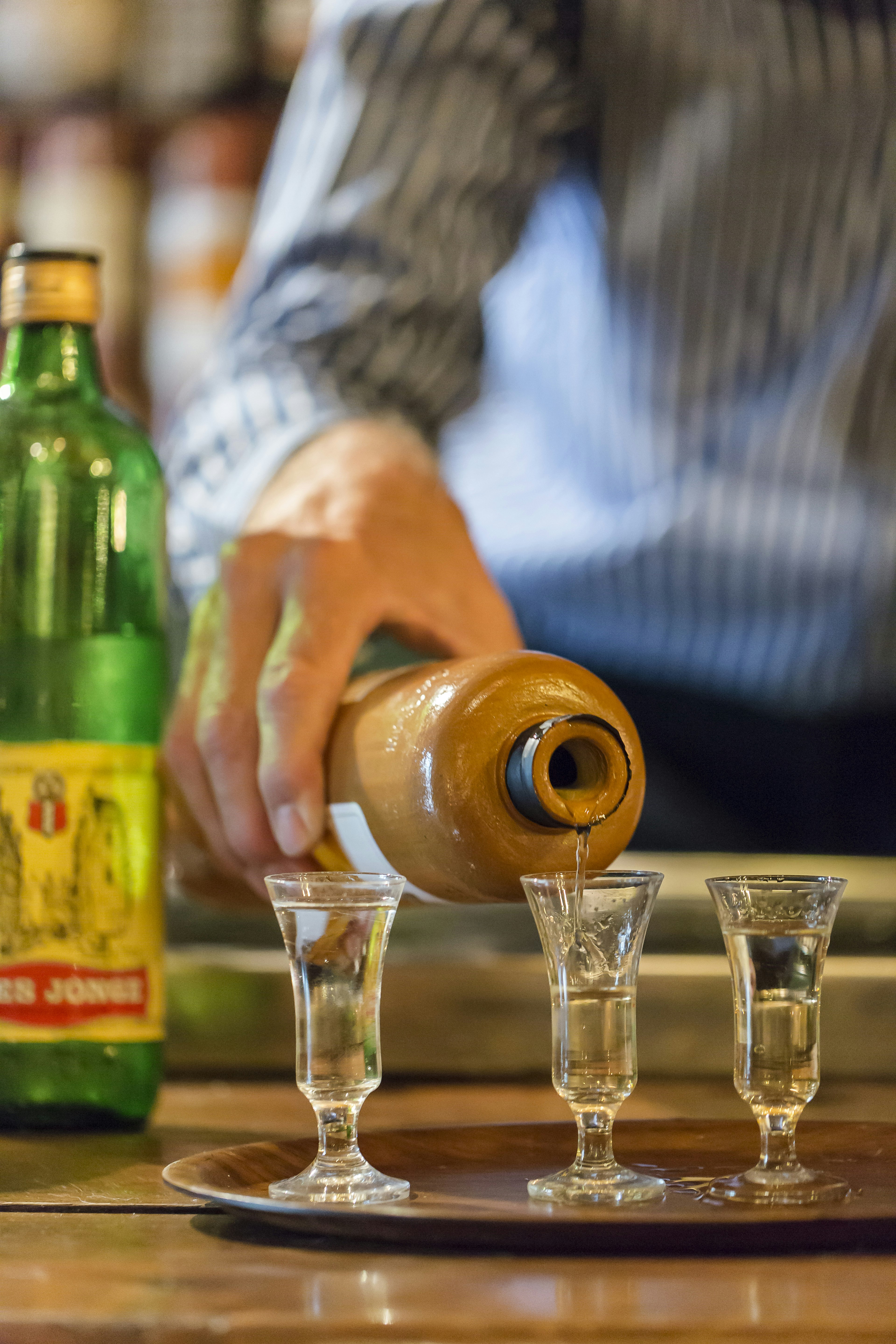 Gin tasting at De Admiraal in Amsterdam where a barman pours gin into tasting glasses.