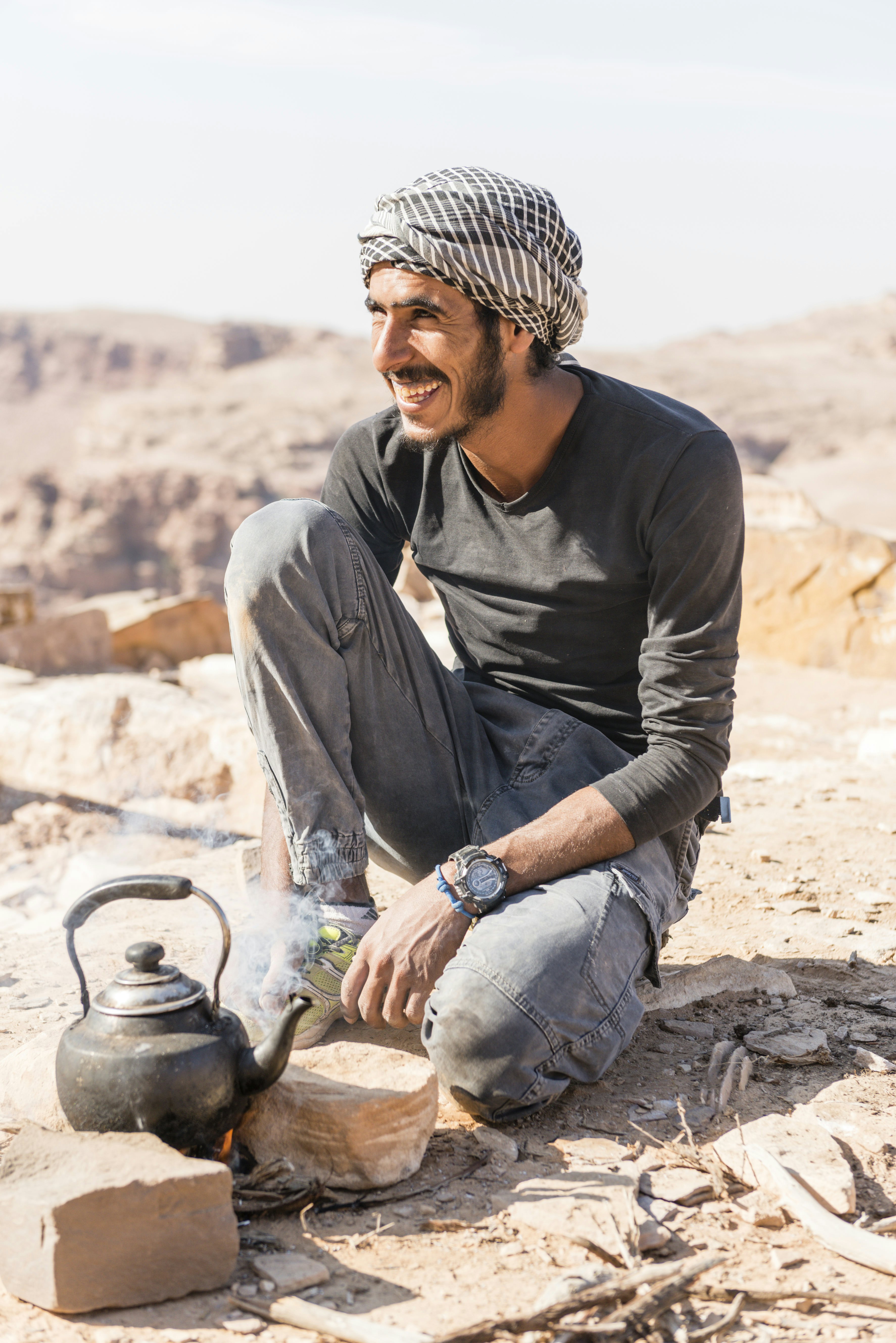 A hiking guide prepares a pot of tea during a trek