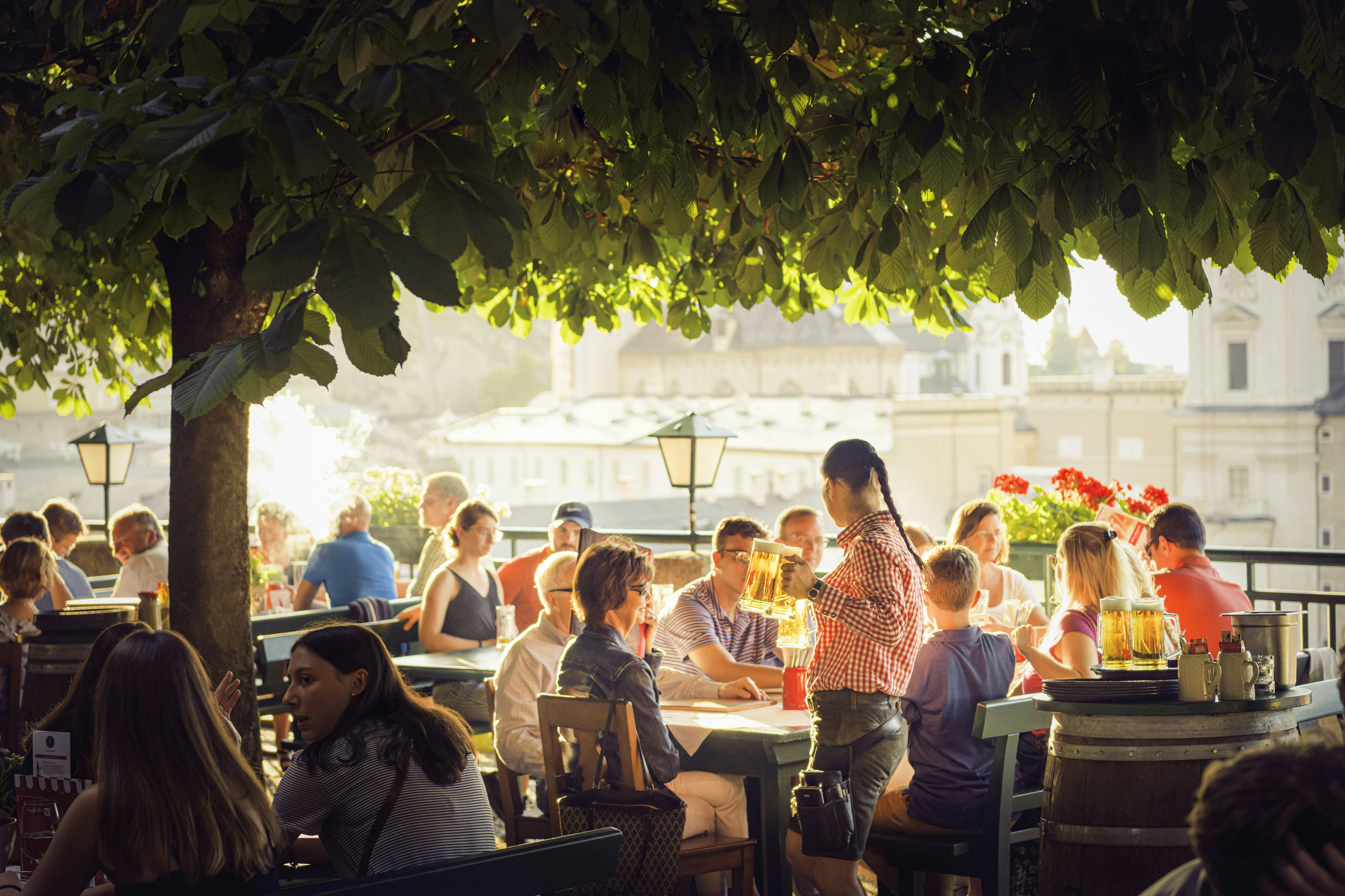 Visitors drinking in the sun at Stieglkeller's beer garden in Salzburg