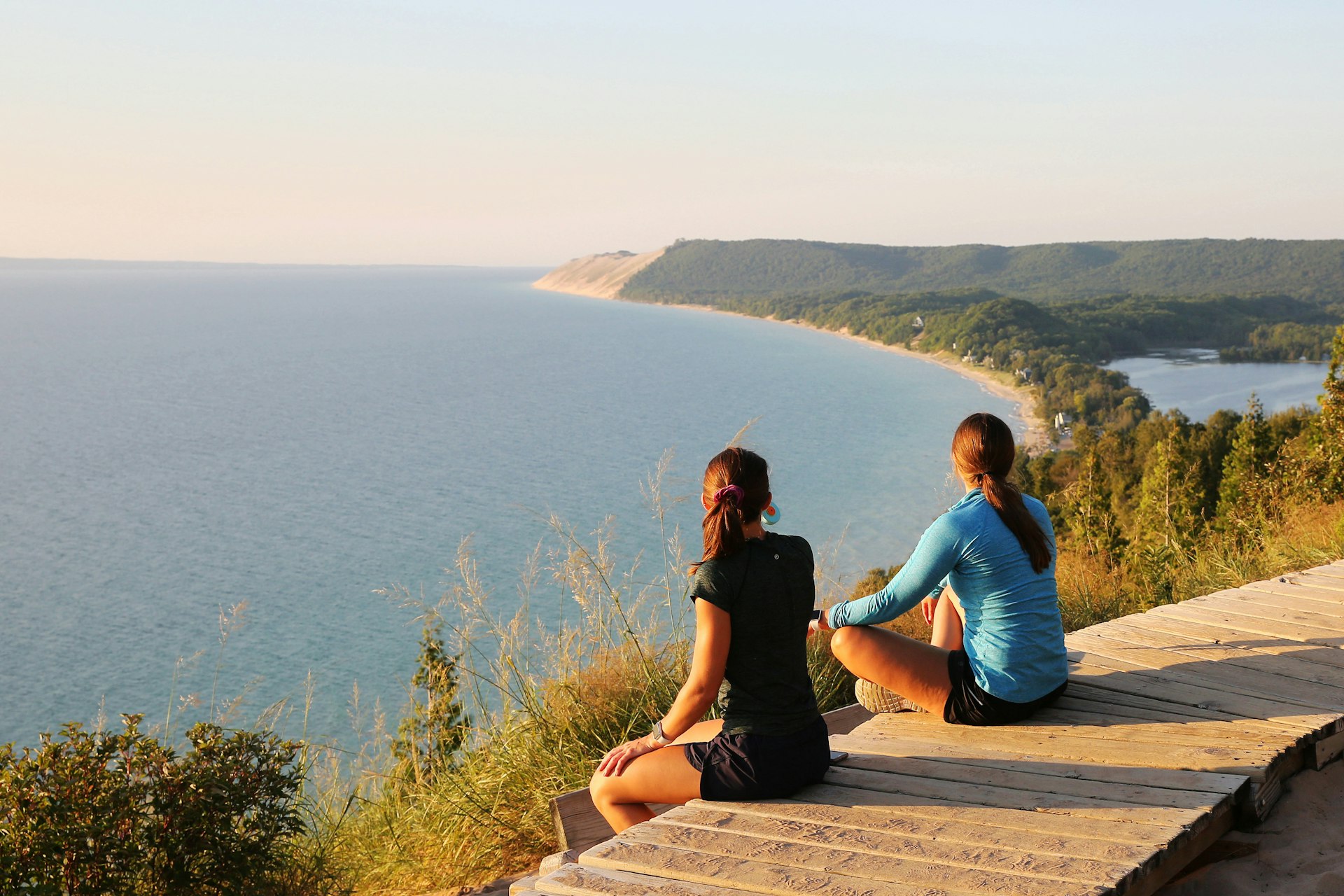 Tourists enjoying beautiful sunset scenery at the Empire Bluff Scenic Lookout, overlooking Lake Michigan, the Sleeping Bear Dunes, and the Manitou Island.