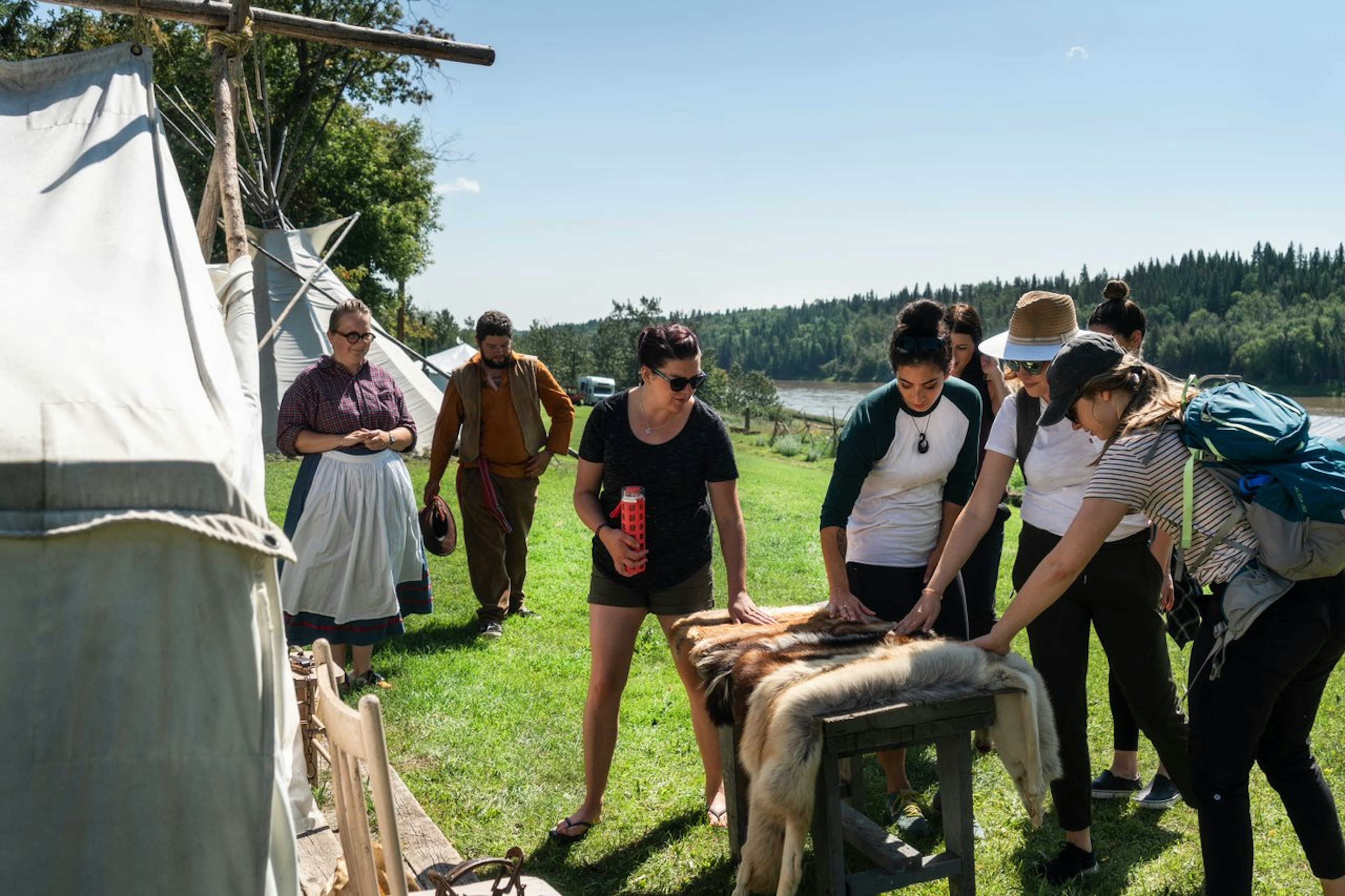 A group of people look at animal pelts at Metis Crossing, Edmonton