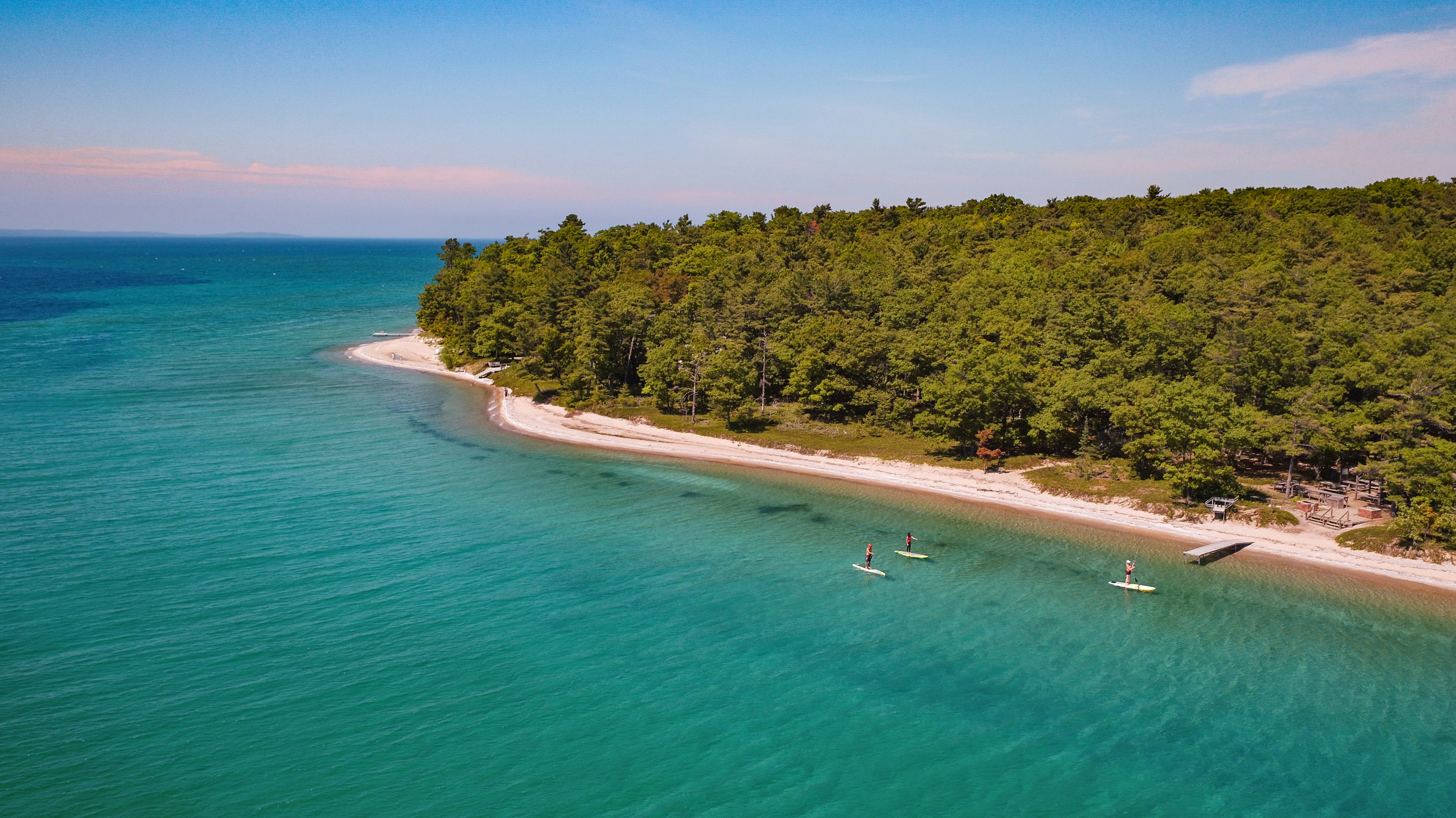 A group of friends explore the west arm of Grand Traverse Bay on stand up paddle boards