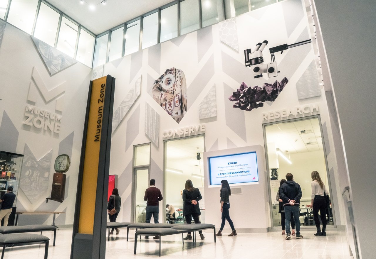 A group of people walk through the galleries of the Royal Alberta Museum