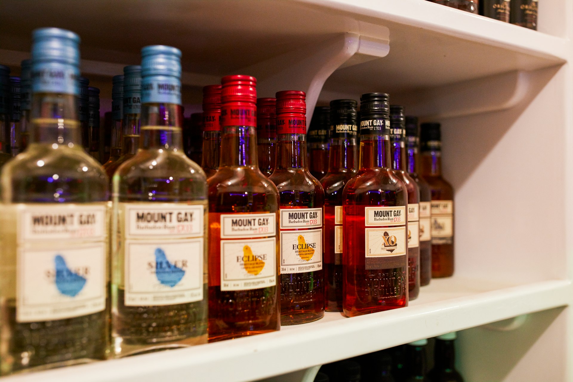 A shelf lined with bottles of rum