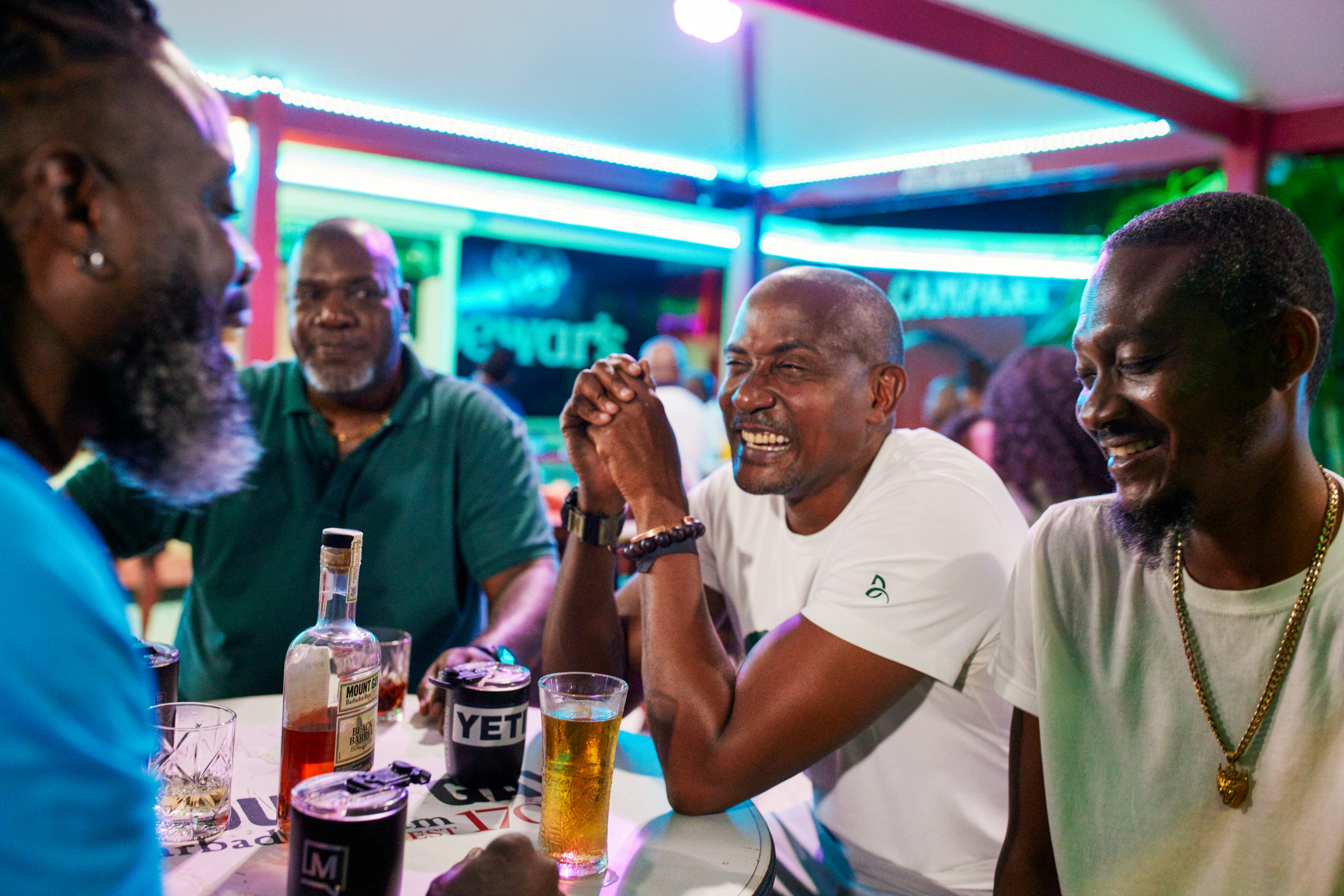 Friends sit at tables, laugh and share a drink