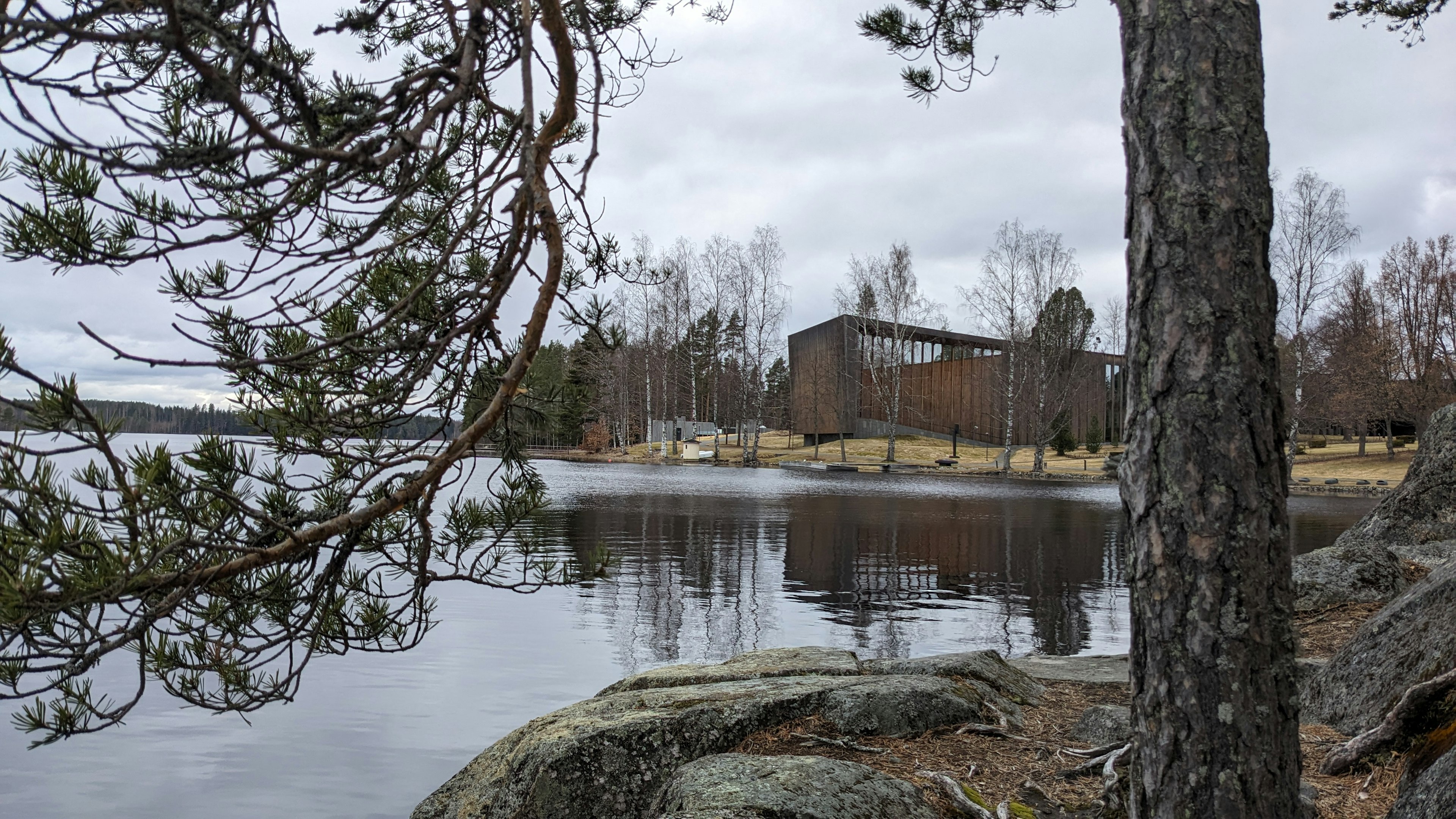 The exterior of a modern building in large open grounds near a lake