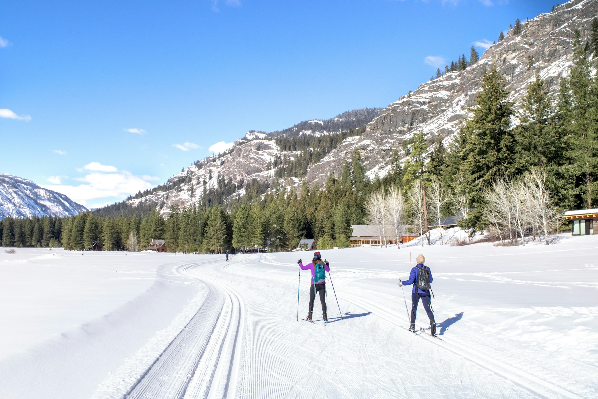 Two cross-country skiers follow a trail
