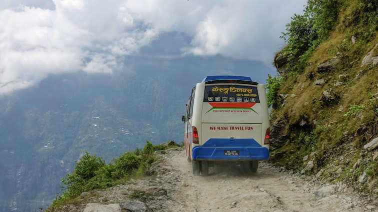 NEPAL COUNTRYSIDE, OCTOBER 2018: CLOSE UP: Colorful tourist bus drives along a scenic road in the green Nepalese mountains. Old bus drives tourists and locals along the scary Pasang Lhamu highway.; Shutterstock ID 1495188476; GL: 65050; netsuite: Lonely Planet Online Editorial; full: How to get around Nepal; name: Brian Healy
1495188476
adventure, asia, asian, beautiful, breathtaking, bus, close up, clouds, countryside, dangerous, dirt, driving, explore, green, greenery, highway, hills, himalaya, journey, landscape, lush, mountain, mountains, nepal, old, outdoors, path, public, road, route, rural, scary, scenery, steep, stunning, terrain, tourism, transport, transportation, travel, trees, trip, unpaved, untouched, valley, vegetation, vehicle, view, wilderness
Colorful tourist bus drives along a scenic road in the green Nepalese mountains. Old bus drives tourists and locals along the scary Pasang Lhamu highway.