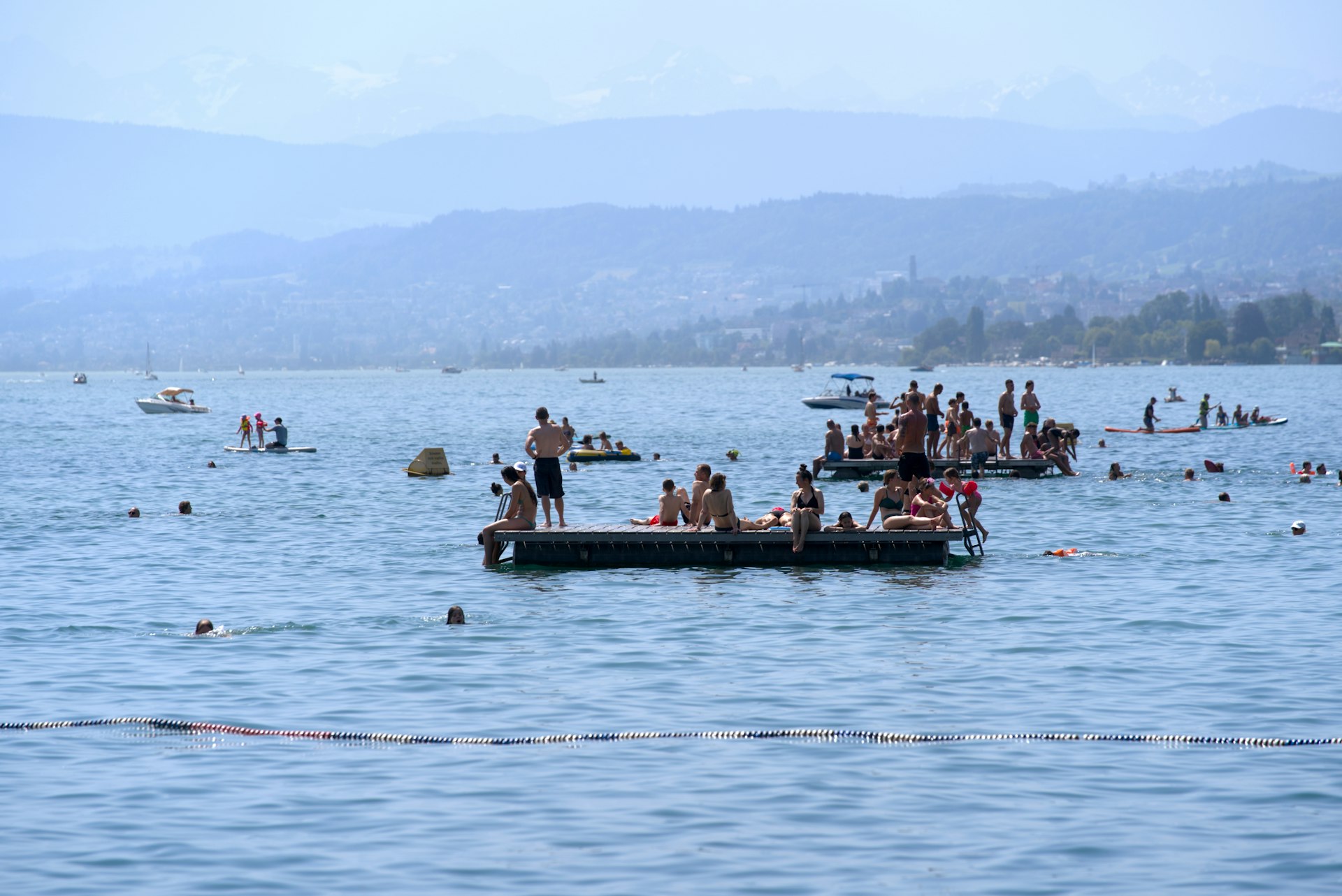 People swimming and sunbathing on floats on Lake Zürich, Zürich, Switzerland