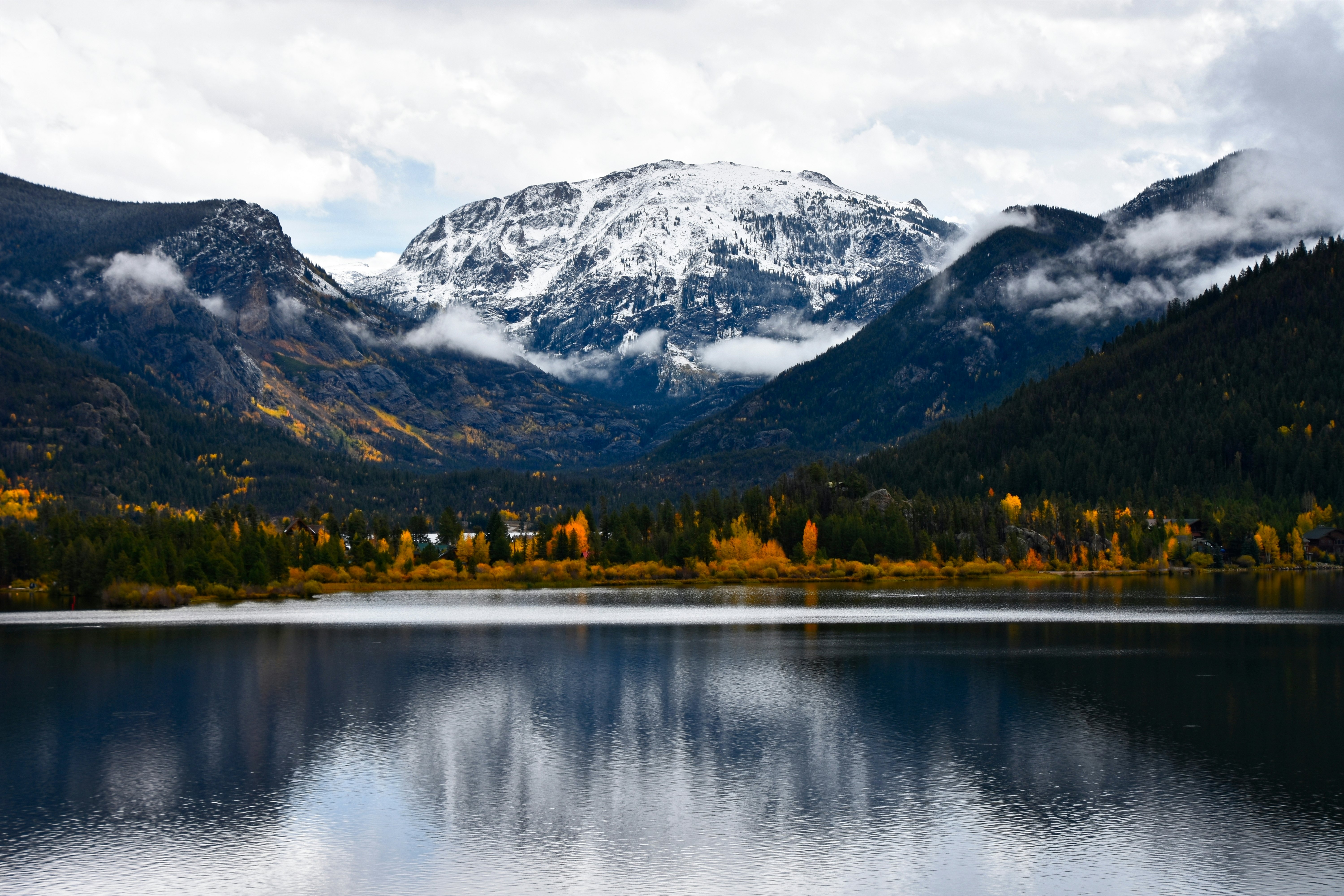 The reflection of a mountain and trees in a lake in the Rocky Mountains.