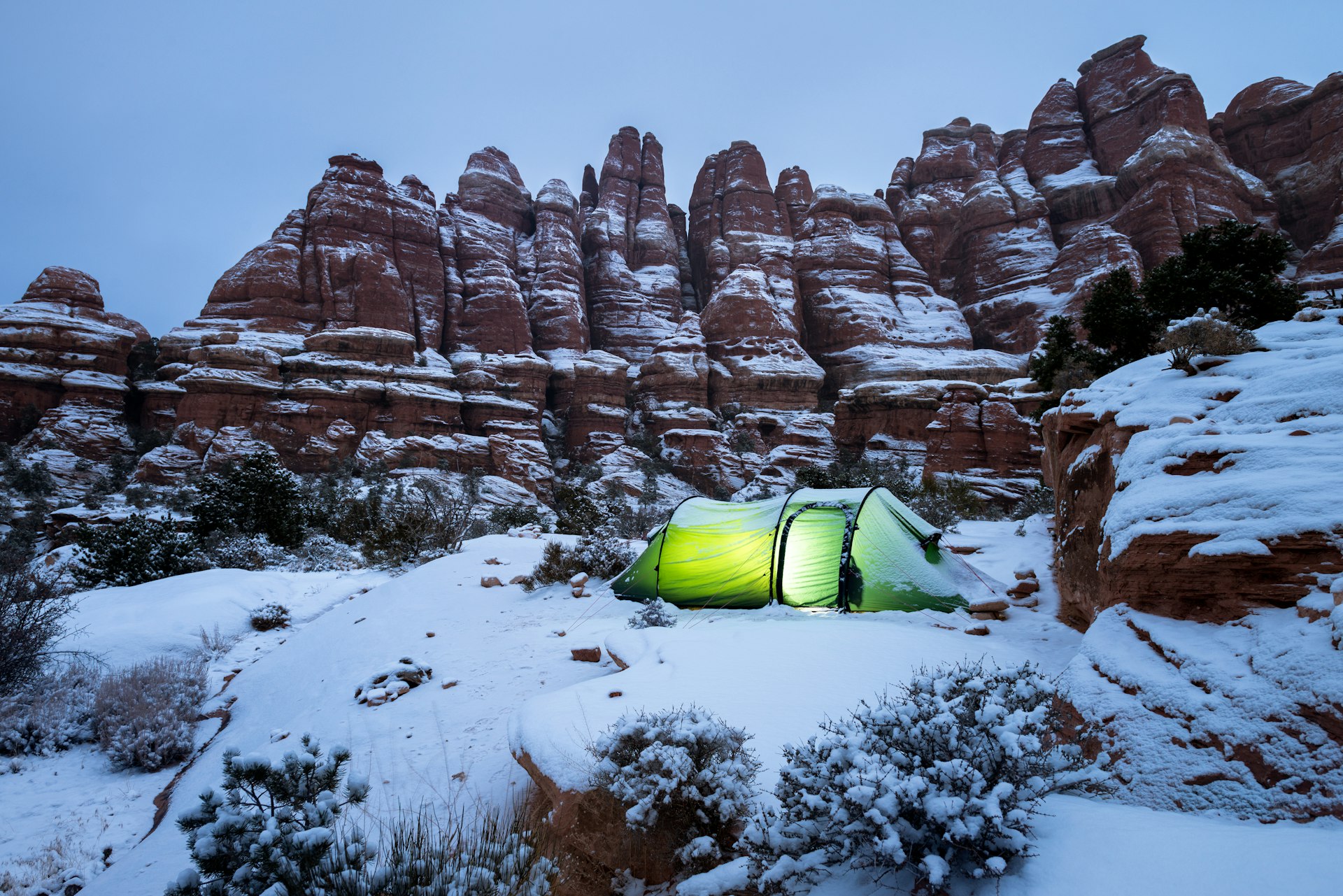 A snow-covered tent after dark in the Utah desert.