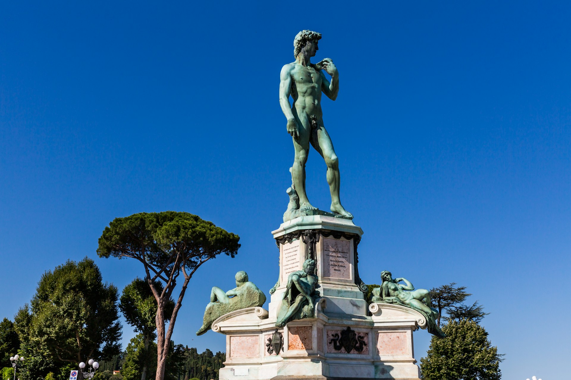 A replica statue of Michelangelo's "David," cast in bronze, stands on a plinth in Piazzale Michelangelo in Florence