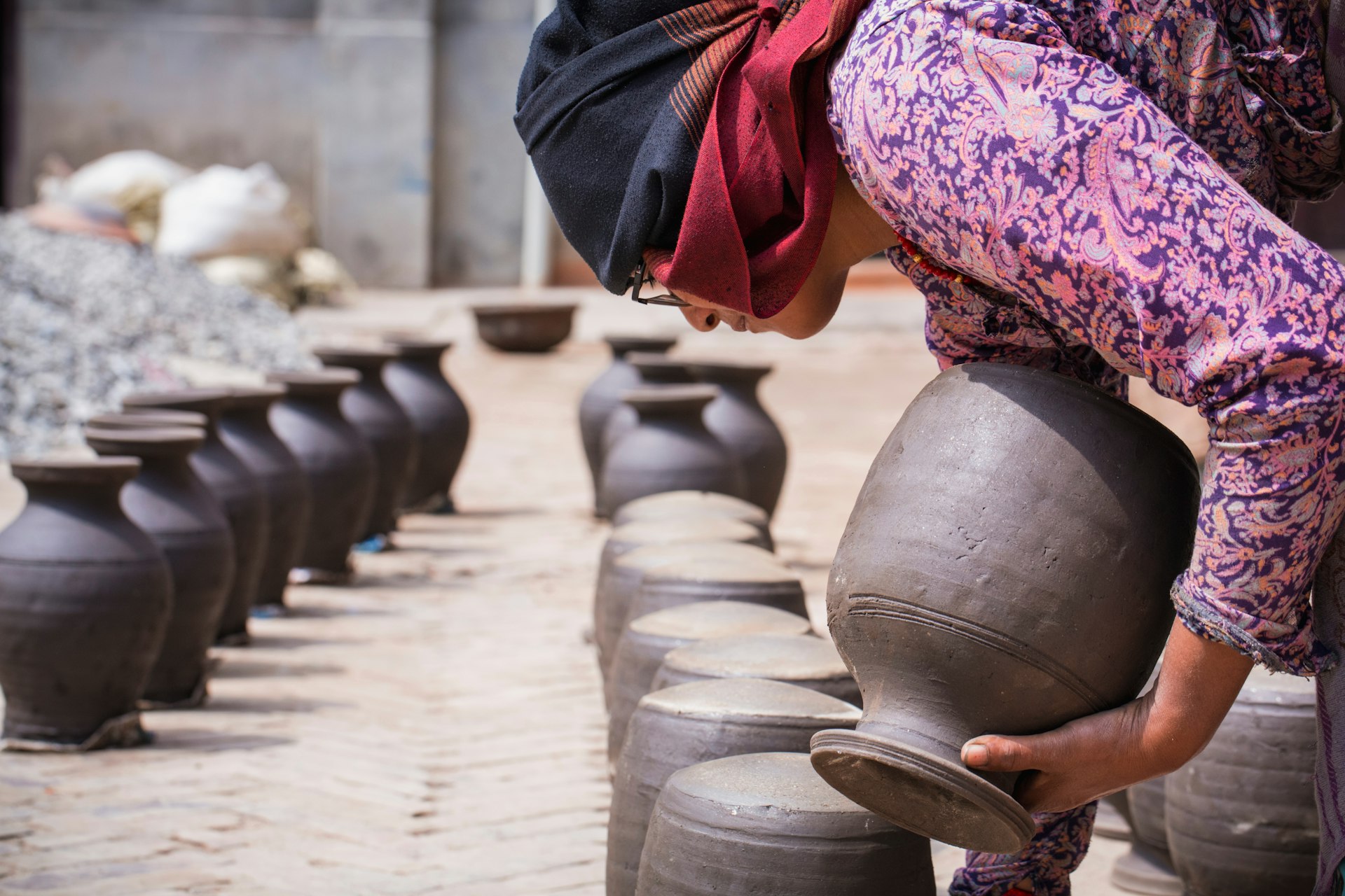 Nepalese woman drying raw clay pot on her workshop, Madhyapur Thimi, Bhaktapur District, Nepal