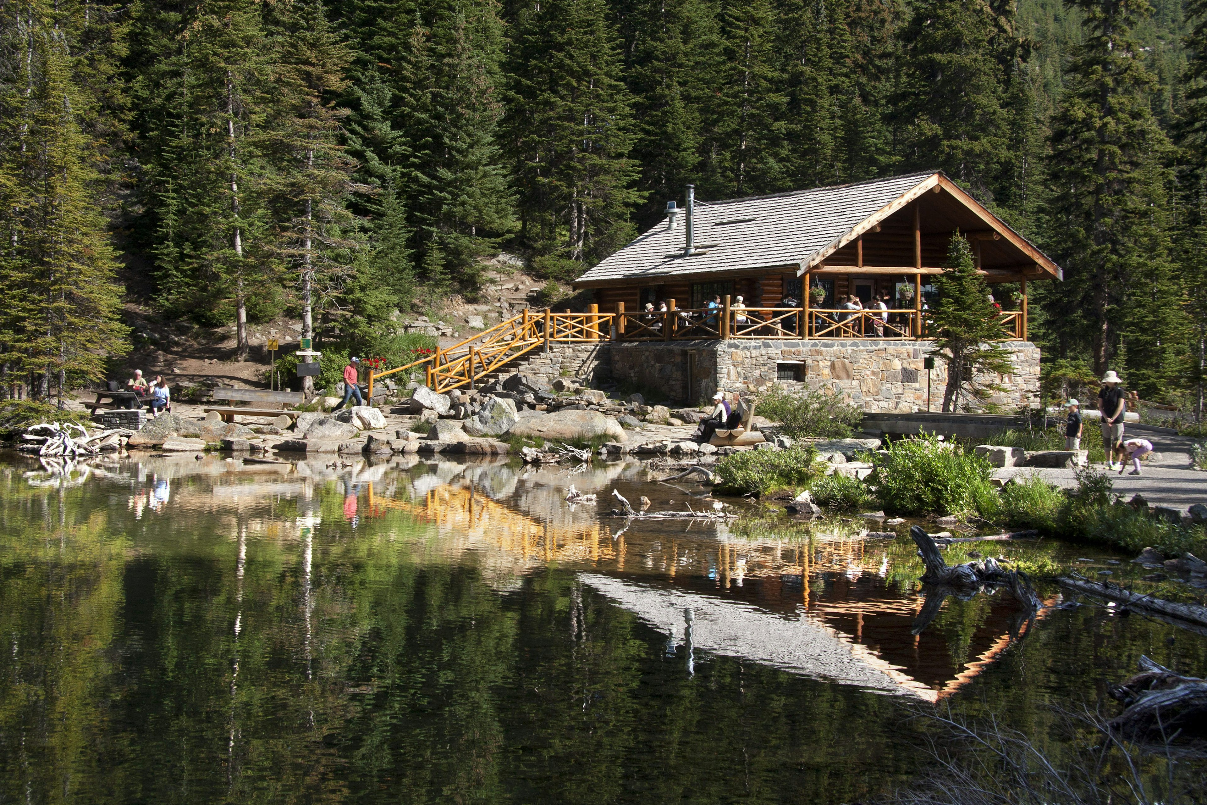 People sit on the porch of Lake Agnes Tea House, Lake Louise, Alberta, Canada