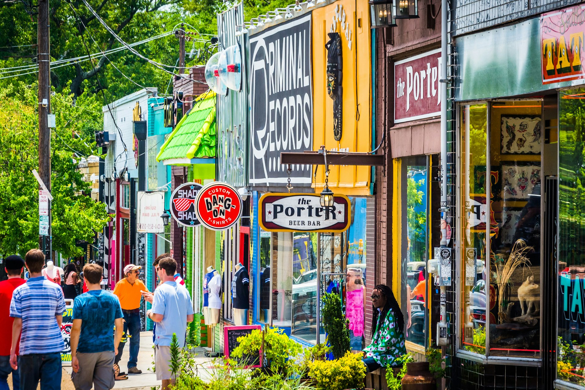 Pedestrians stroll past colorful storefronts in the Little Five Points neighborhood in Altlanta on a sunny day