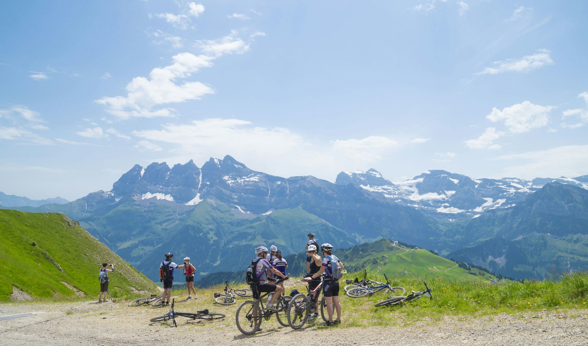 Mountain bikers stop for a break at a picturesque lookout over the Swiss Alps, in the Portes du Soleil region.