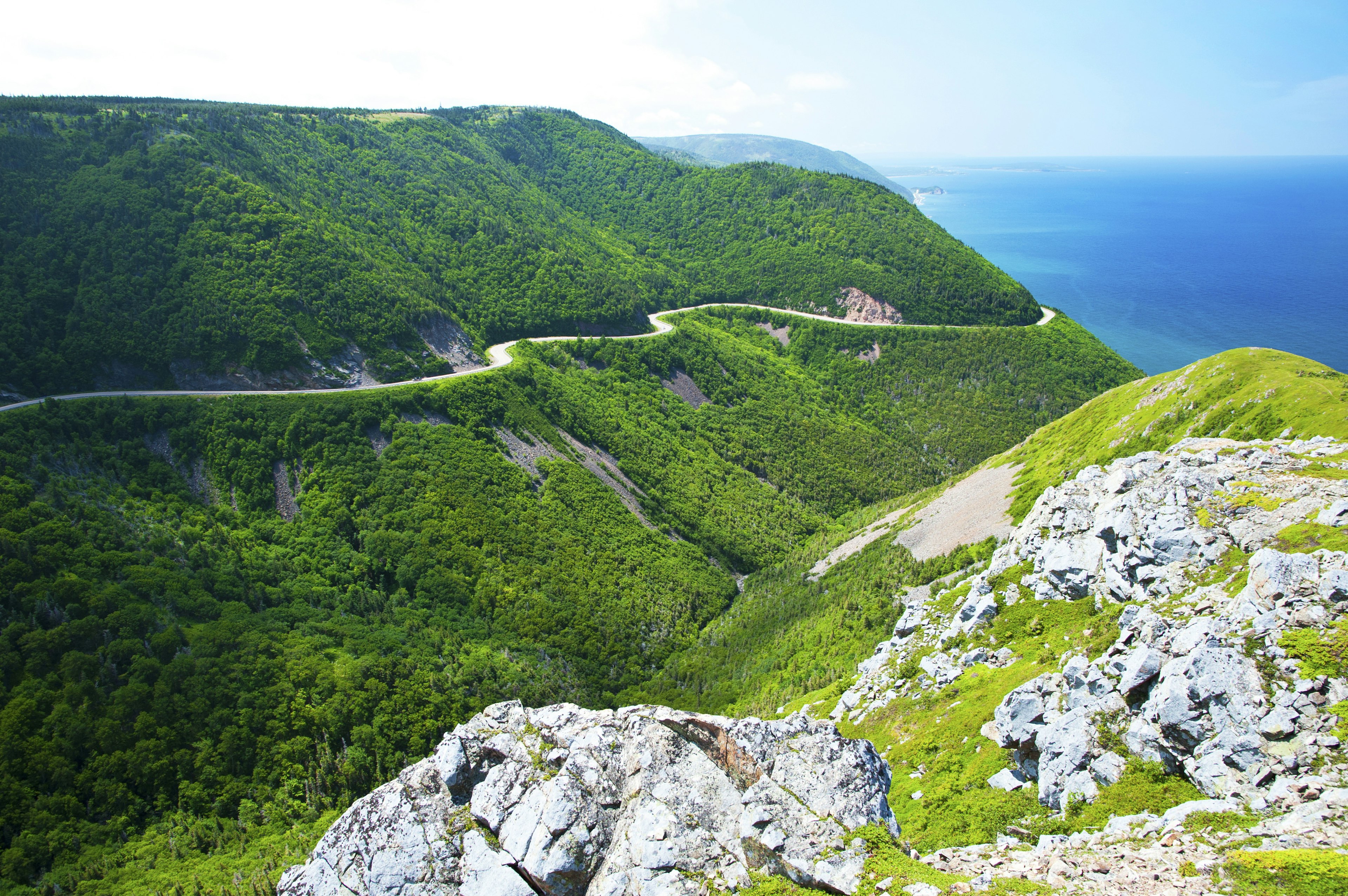 A road winds around hills hugging the coastline