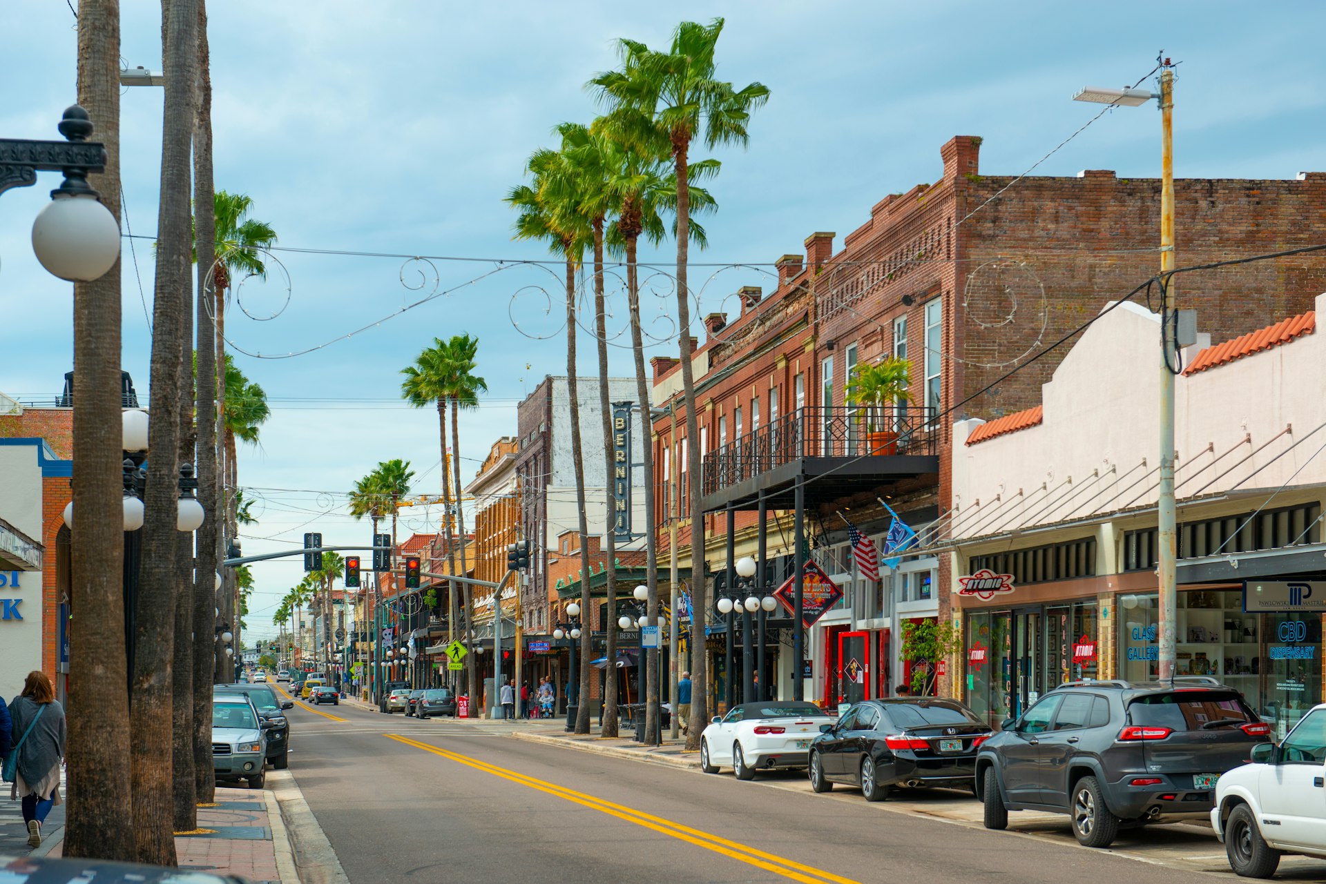 A historic street in Tampa's Ybor City lined with old brick buildings and palm trees