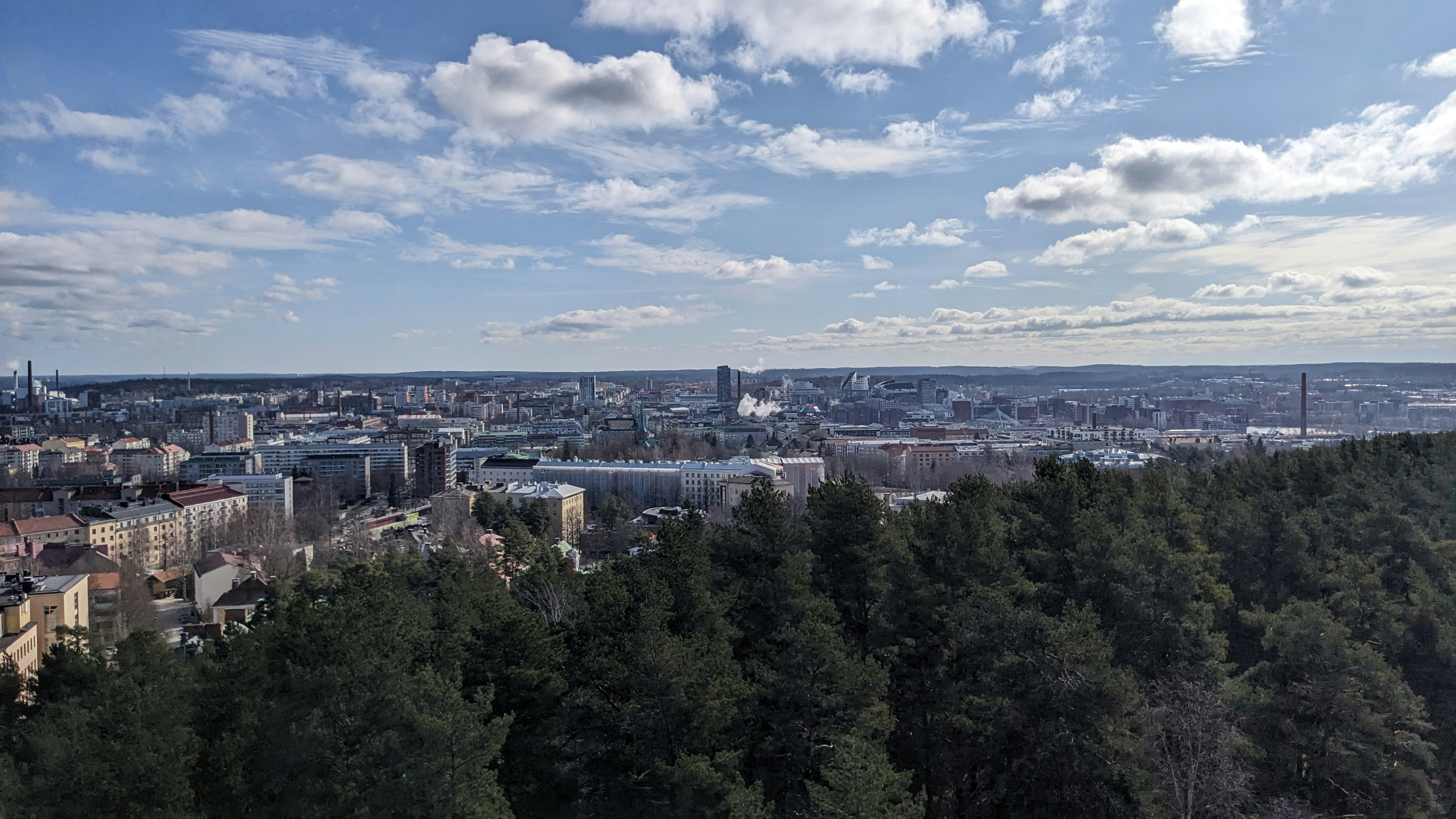 A view over trees towards a city skyline