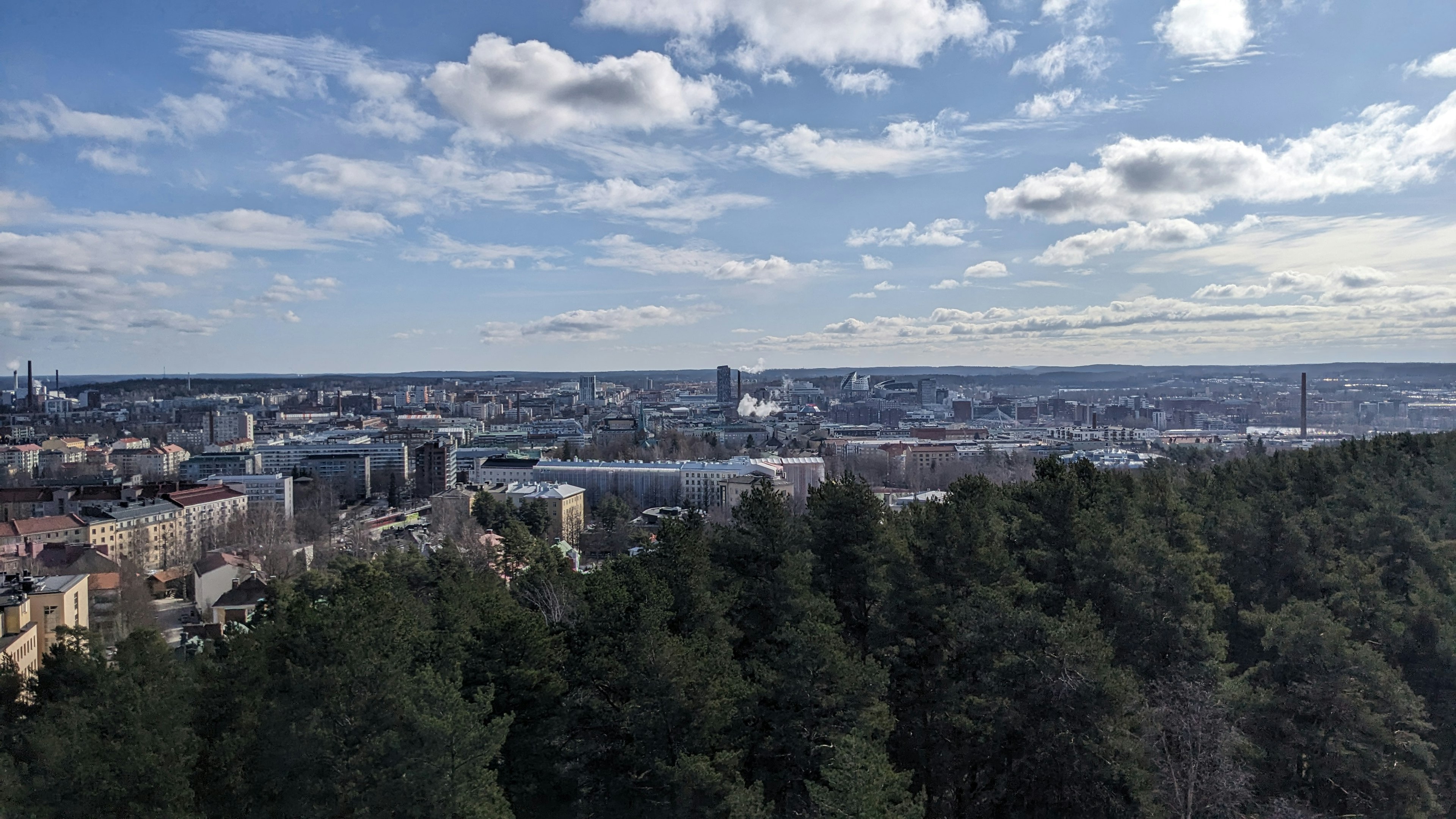 A view over trees towards a city skyline