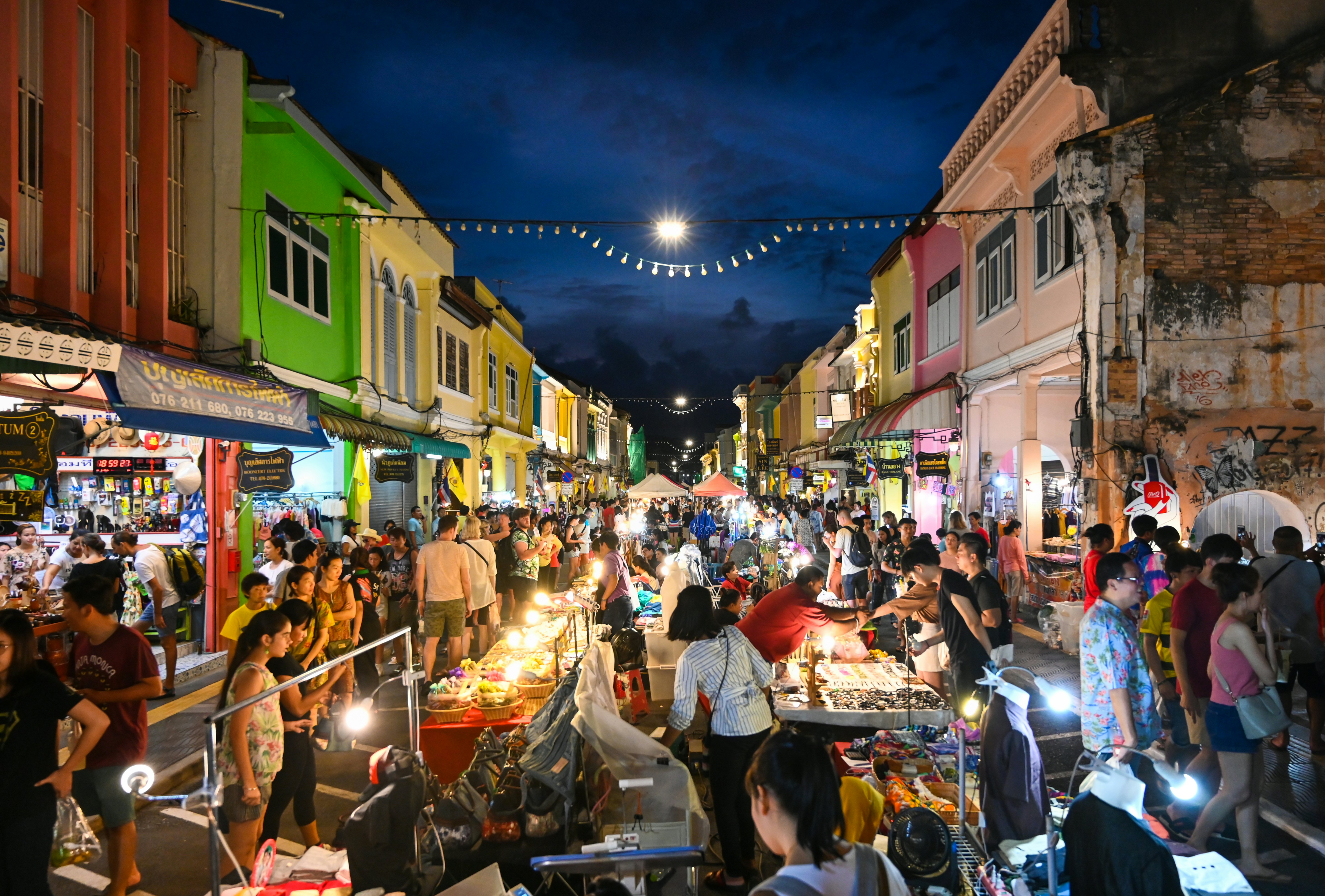 Many tourists are walking along the street at Lard Yai, Phuket weekend market, in Phuket old town area, Thailand.