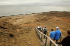 A group of tourists walking down a wooden footpath on the Galapagos Islands, Ecuador
