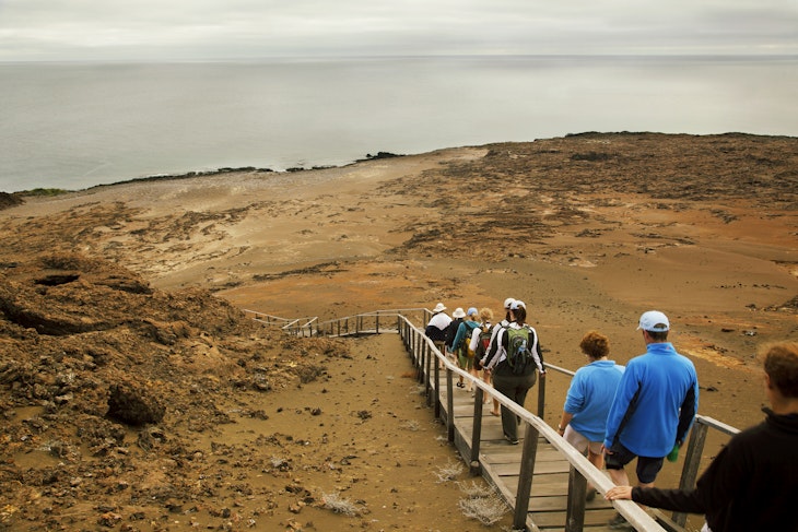 A group of tourists walking down a wooden footpath on the Galapagos Islands, Ecuador