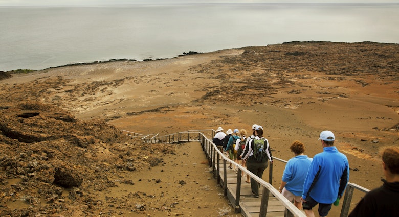 A group of tourists walking down a wooden footpath on the Galapagos Islands, Ecuador