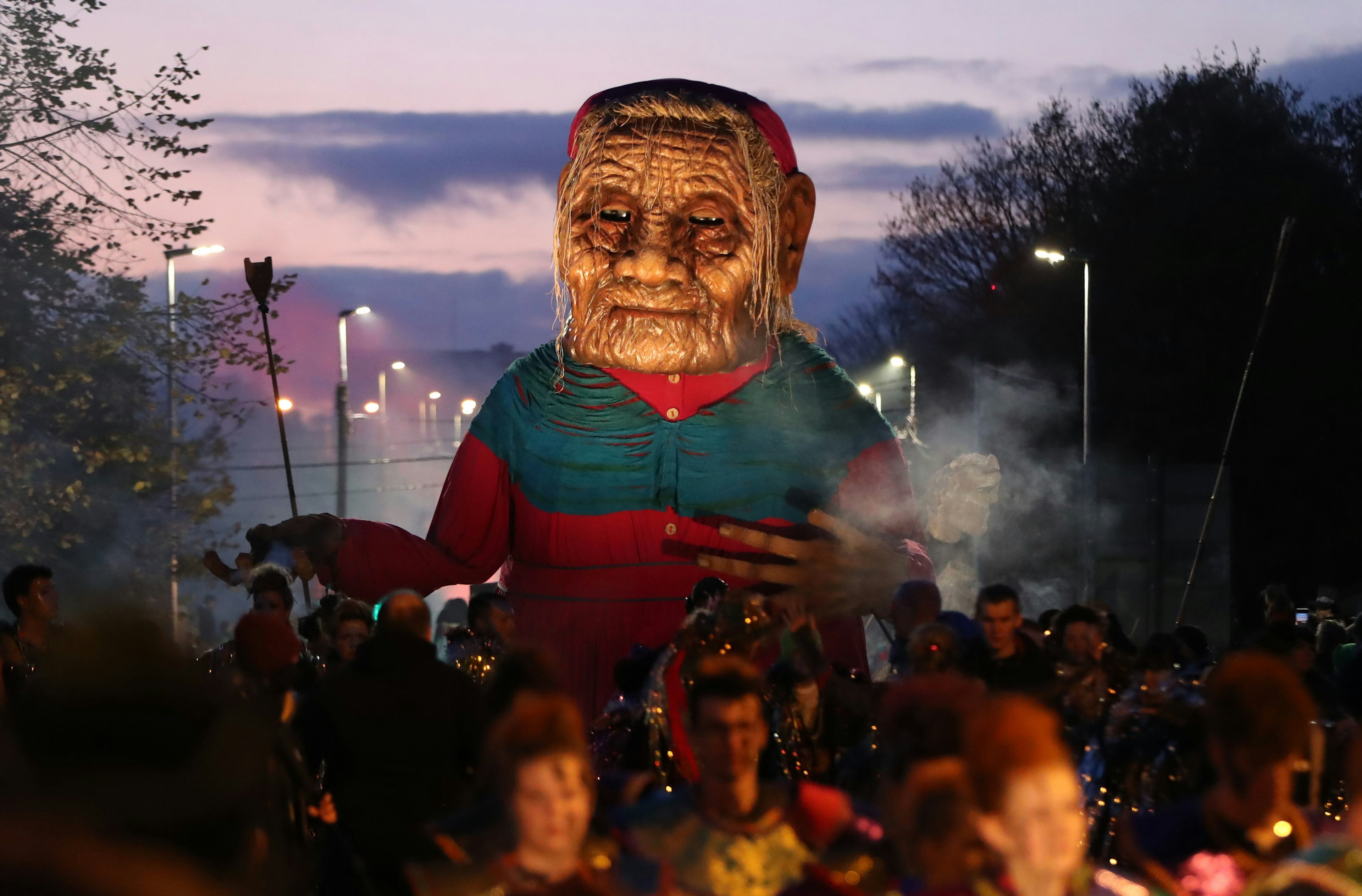 A large parade float of a spooky man floats above Galway in a Halloween parade.