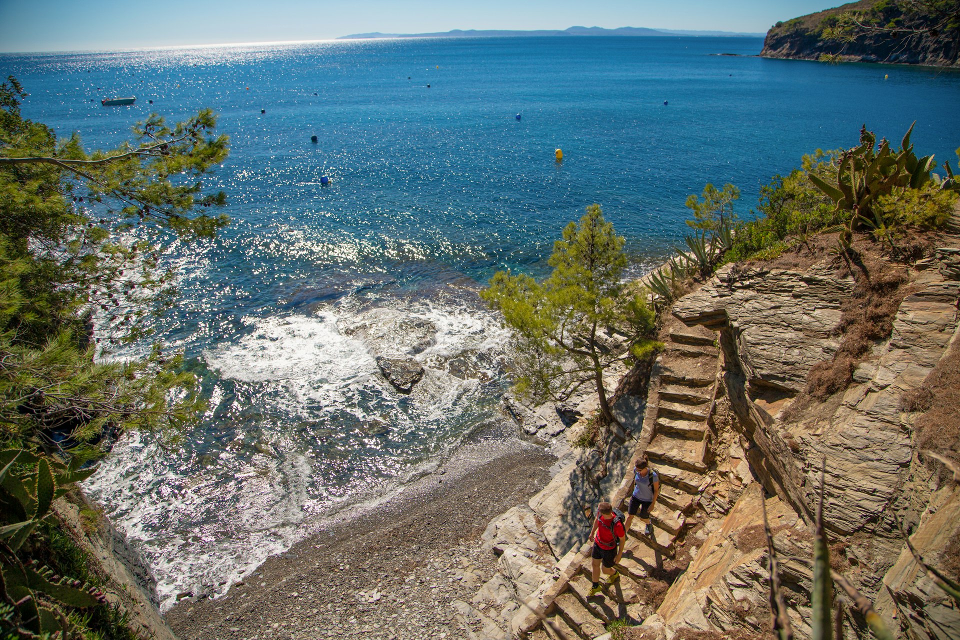High up view of walkers walking down steps to secluded beach, Cami de Ronda, Costa Brava