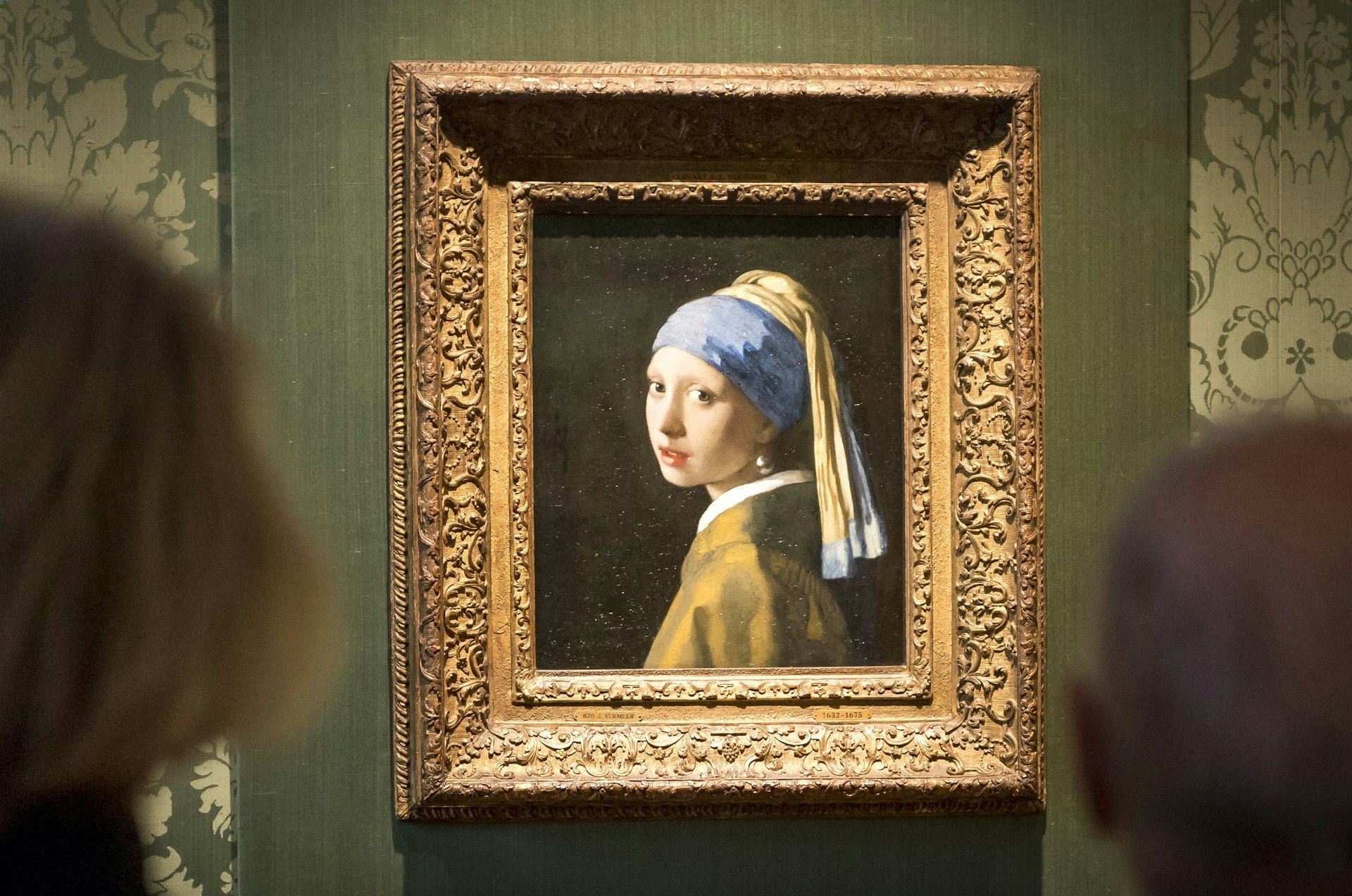 People look at Vermeer’s “Girl with a Pearl Earring” at the Mauritshuis museum, The Hague, Netherlands