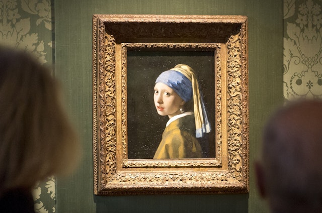 People look at Vermeer’s “Girl with a Pearl Earring” at the Mauritshuis museum, The Hague, Netherlands