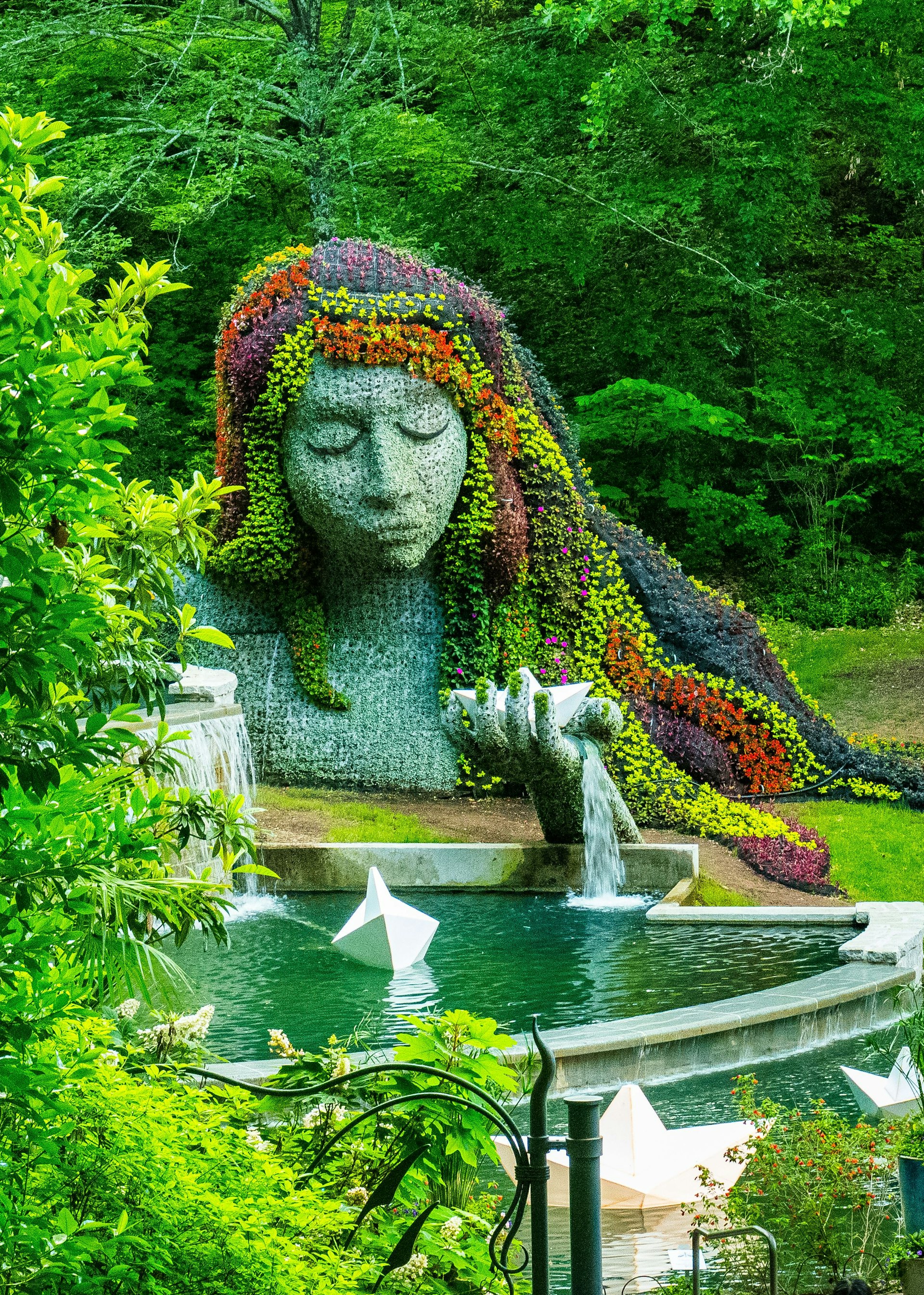 A water feature and floral display in the shape of a woman's head and shoulders at Atlanta Botanical Garden