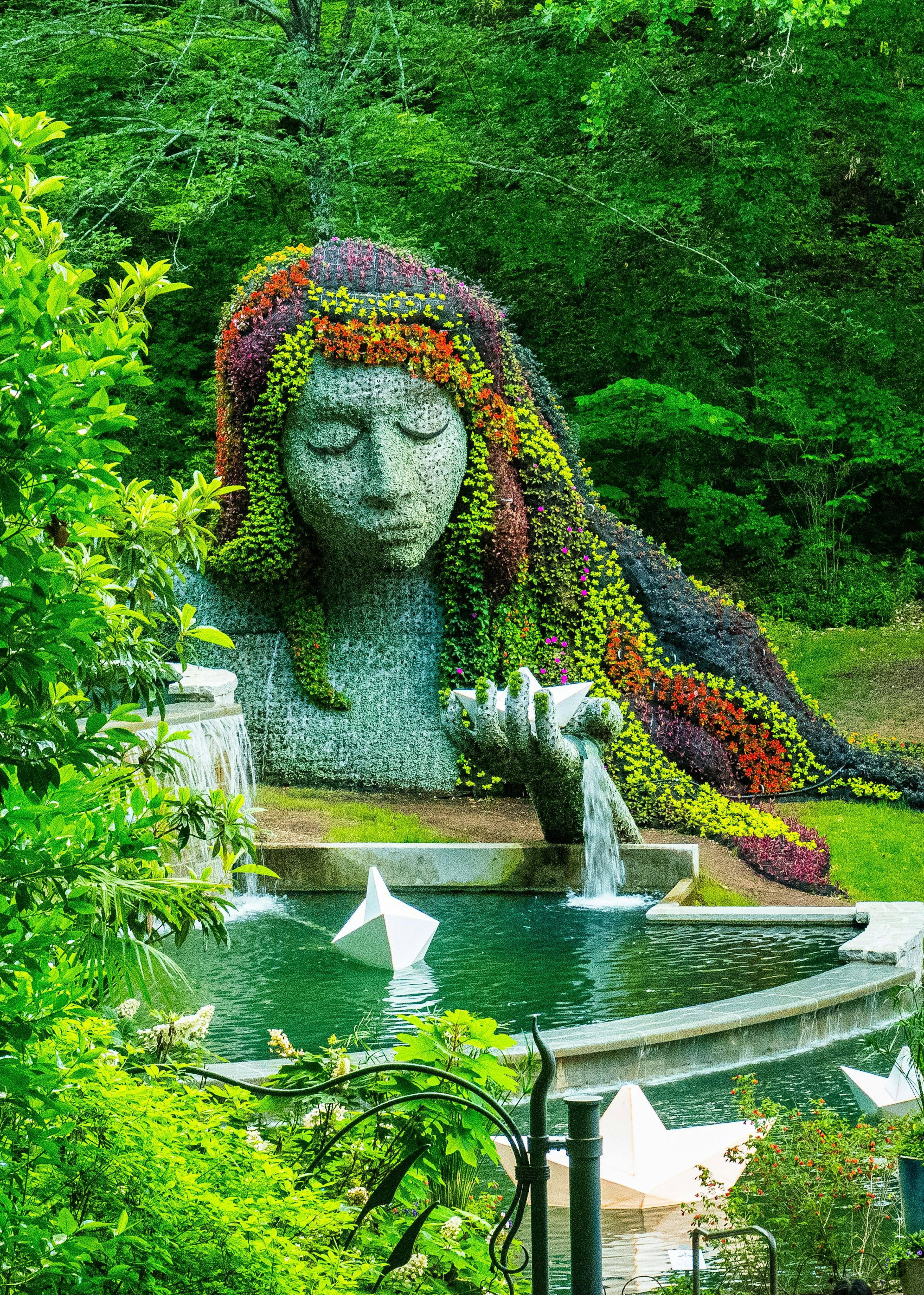 A water feature and floral display in the shape of a woman's head and shoulders at Atlanta Botanical Garden