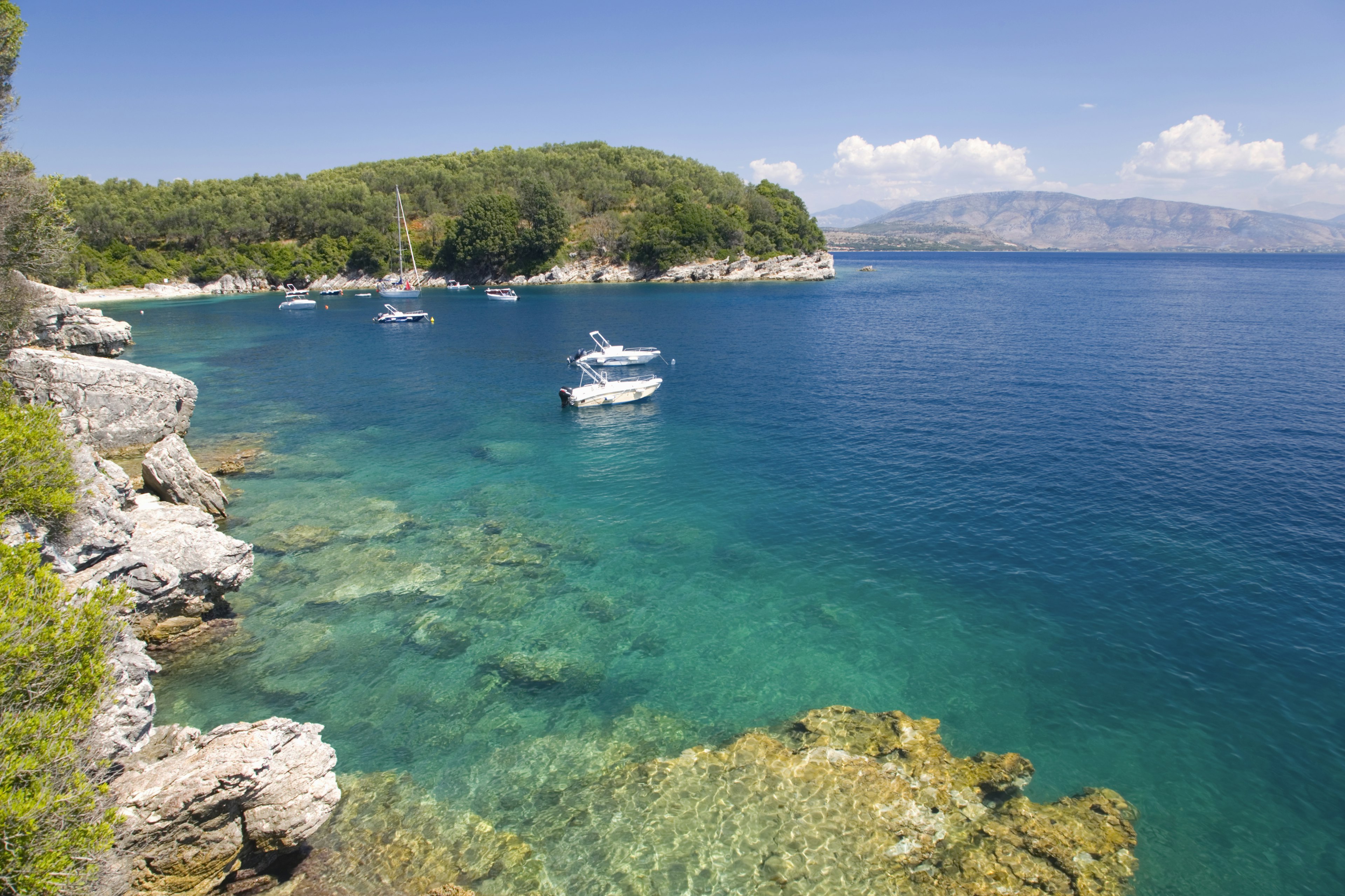 A few small boats anchored in a bay with turquoise waters